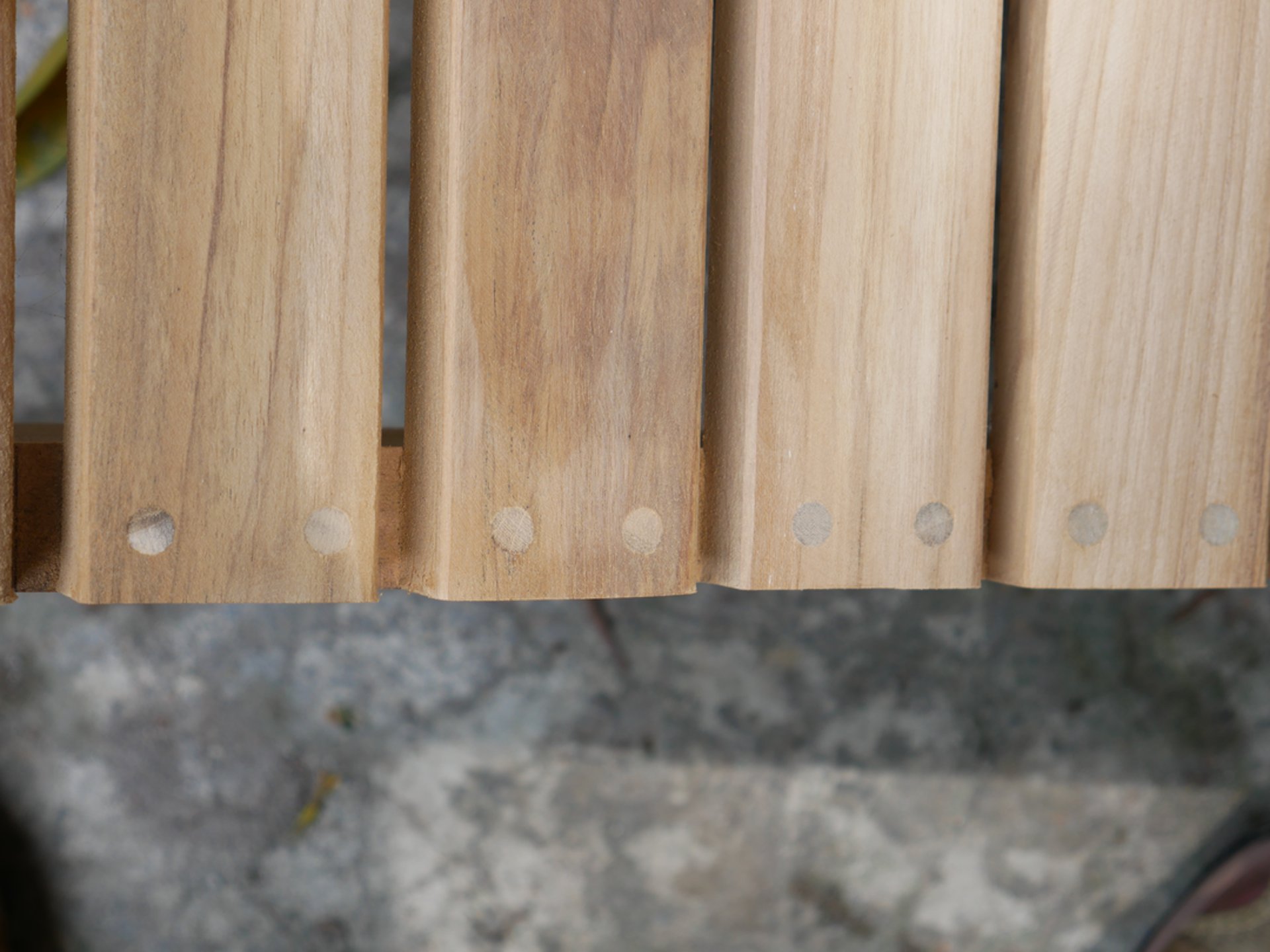 man in white striped shirt sitting on brown pallet holding gray power tool