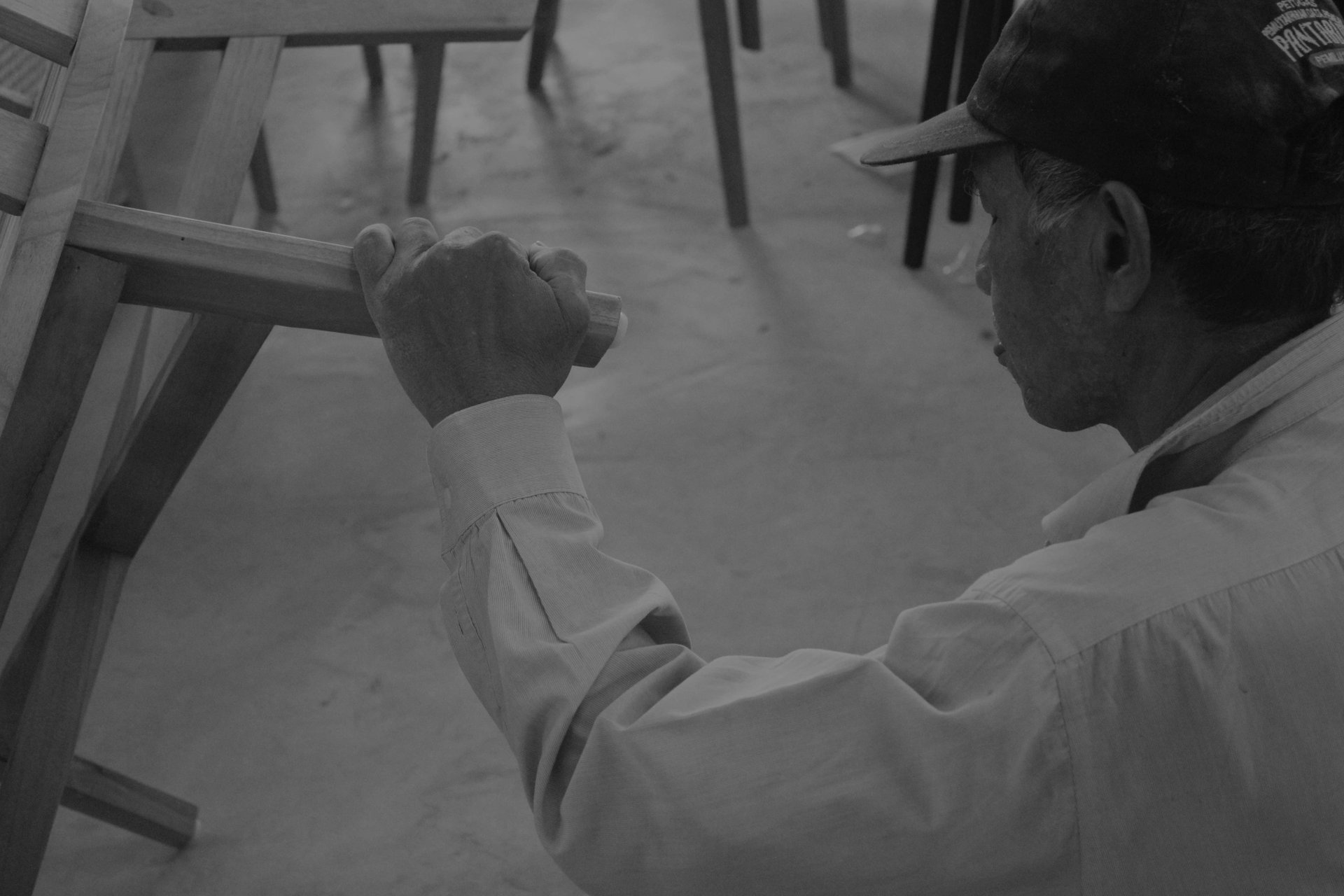 person using chisel while curving wood