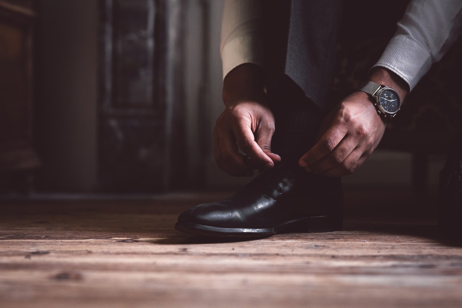 Des mains laçant des chaussures noires