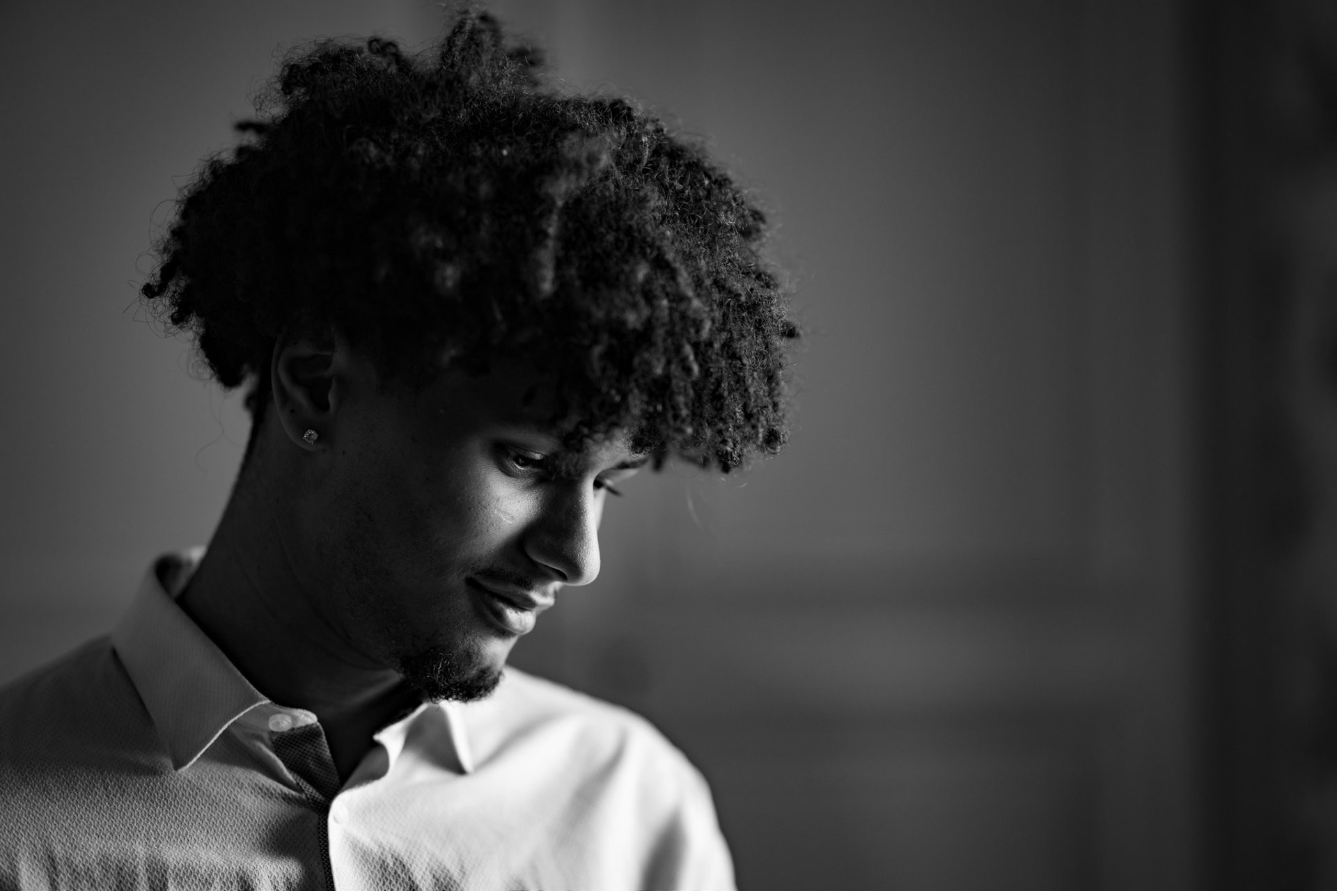 Un homme en chemise blanche regardant vers le sol