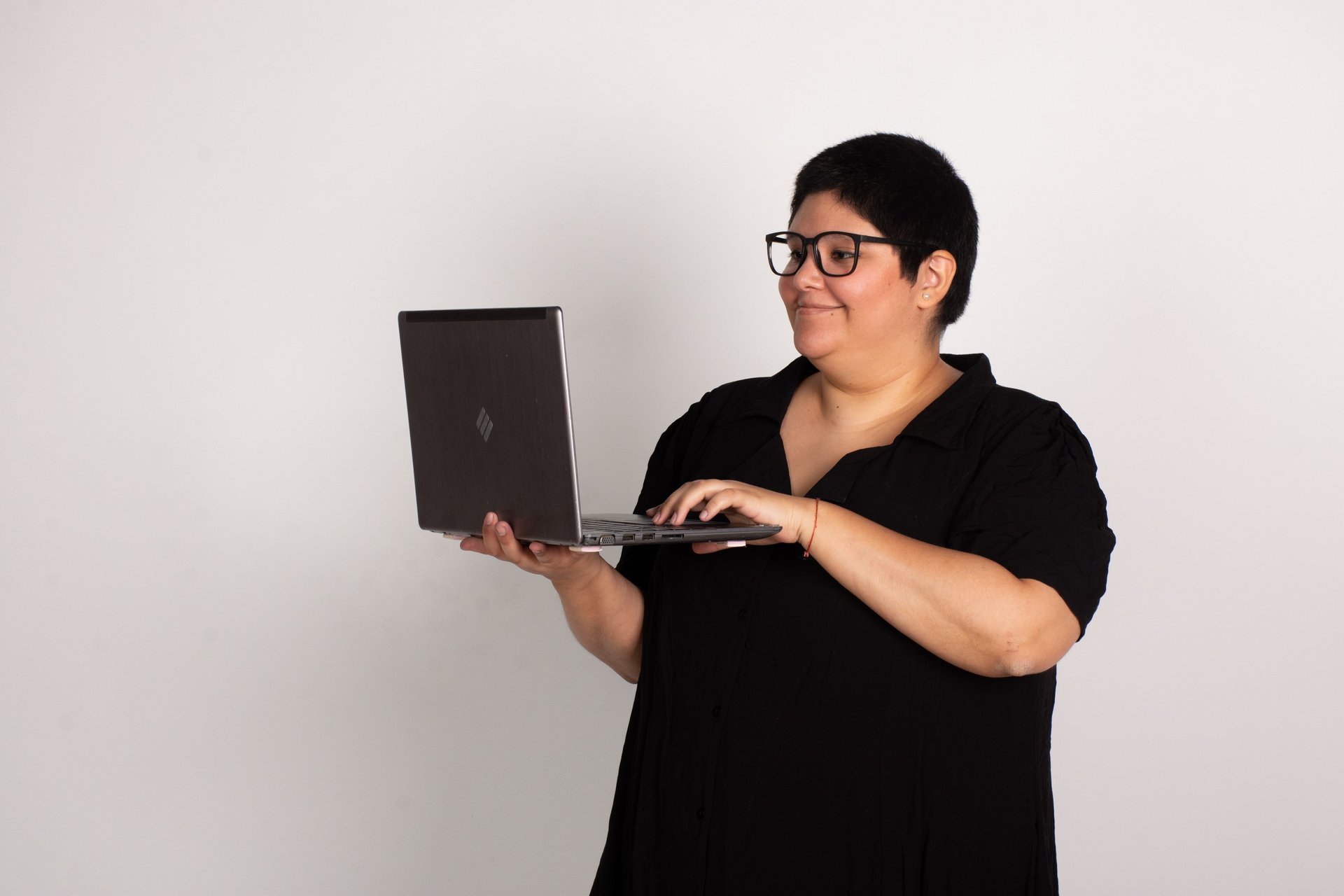 person using MacBook Pro and holding cappuccino