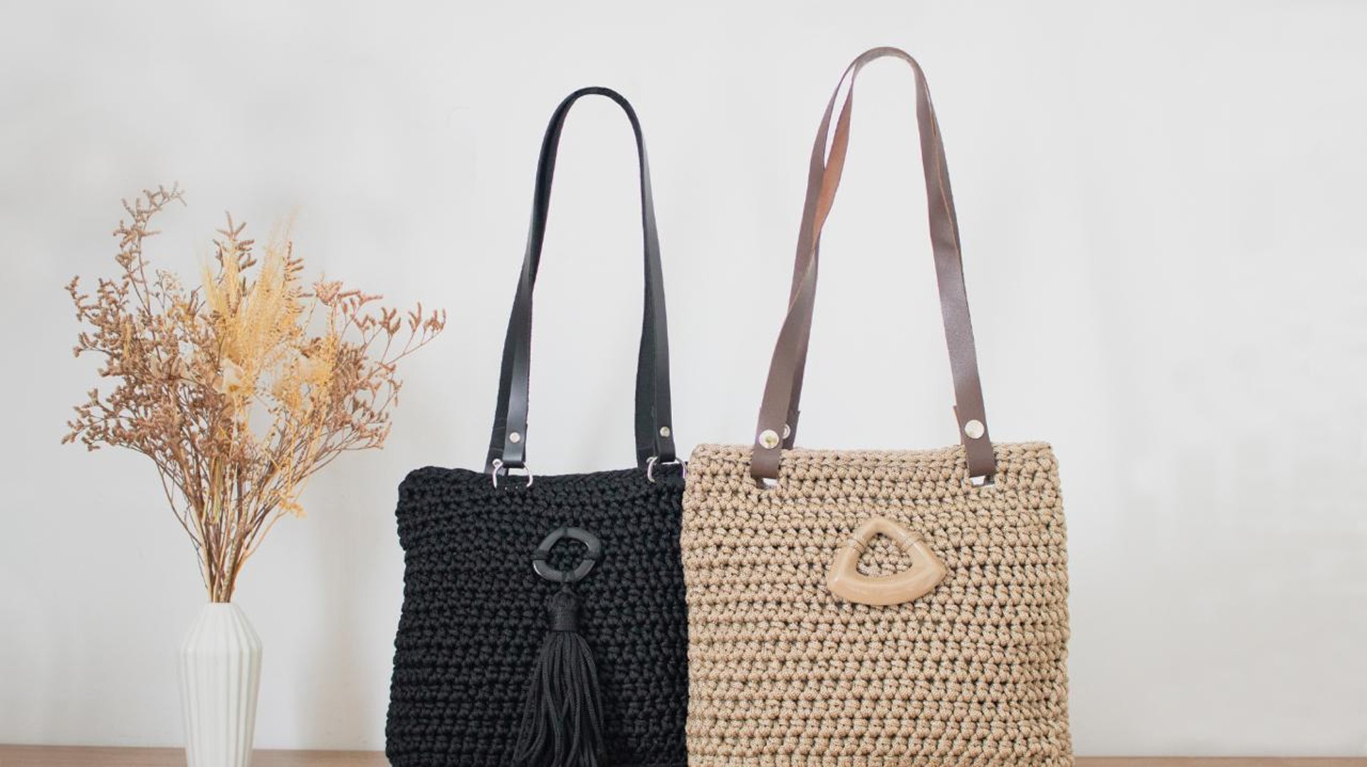 a crocheted blue purse with a brown strap