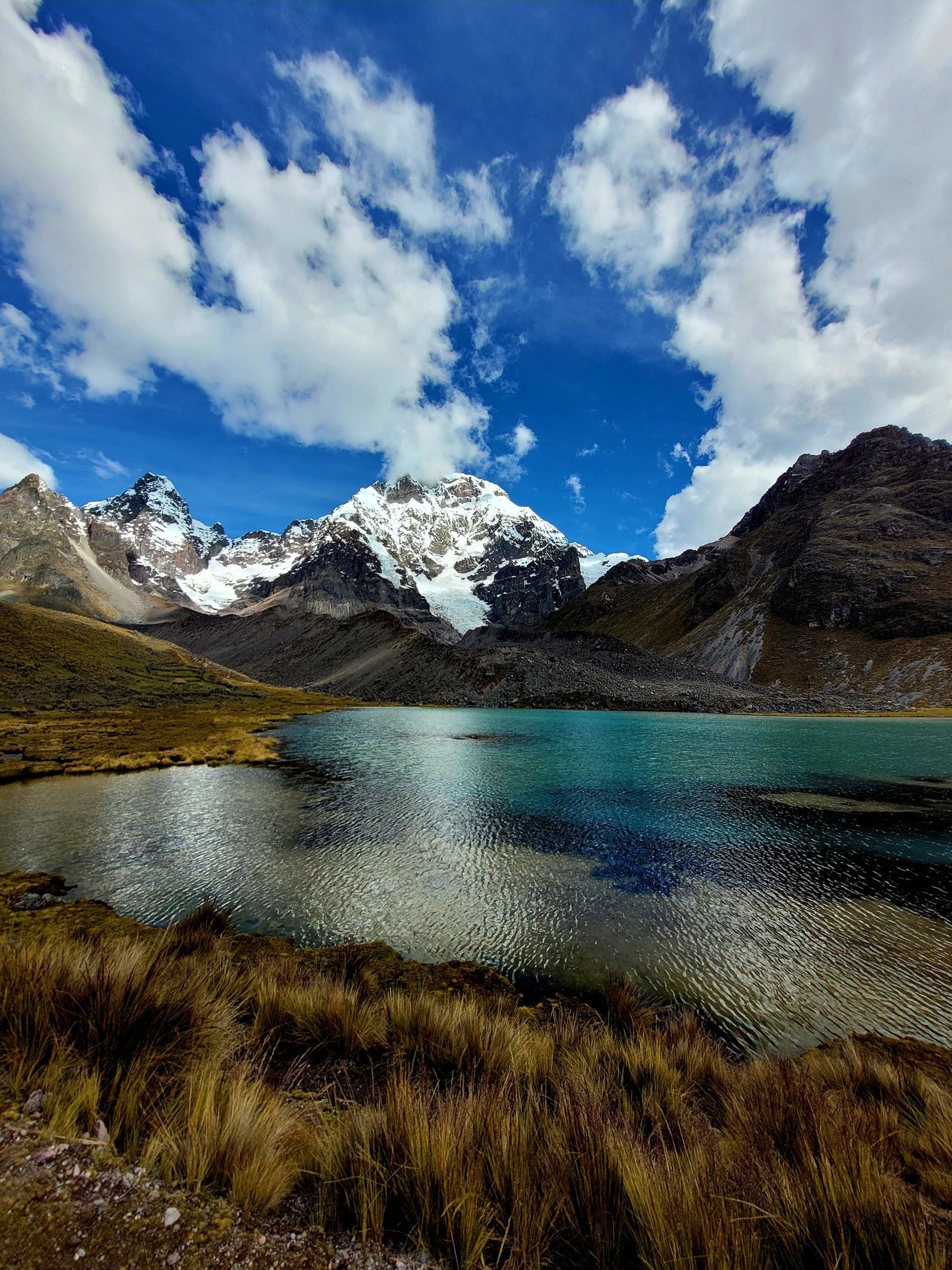 Glacial lake and mountains under blue sky