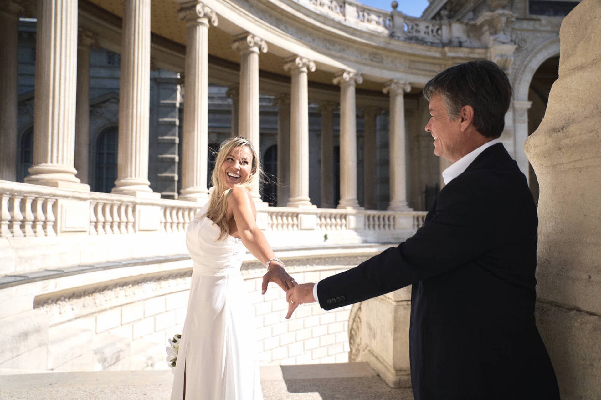 couple de mariés se tenant par la main et partageant un éclat de rire