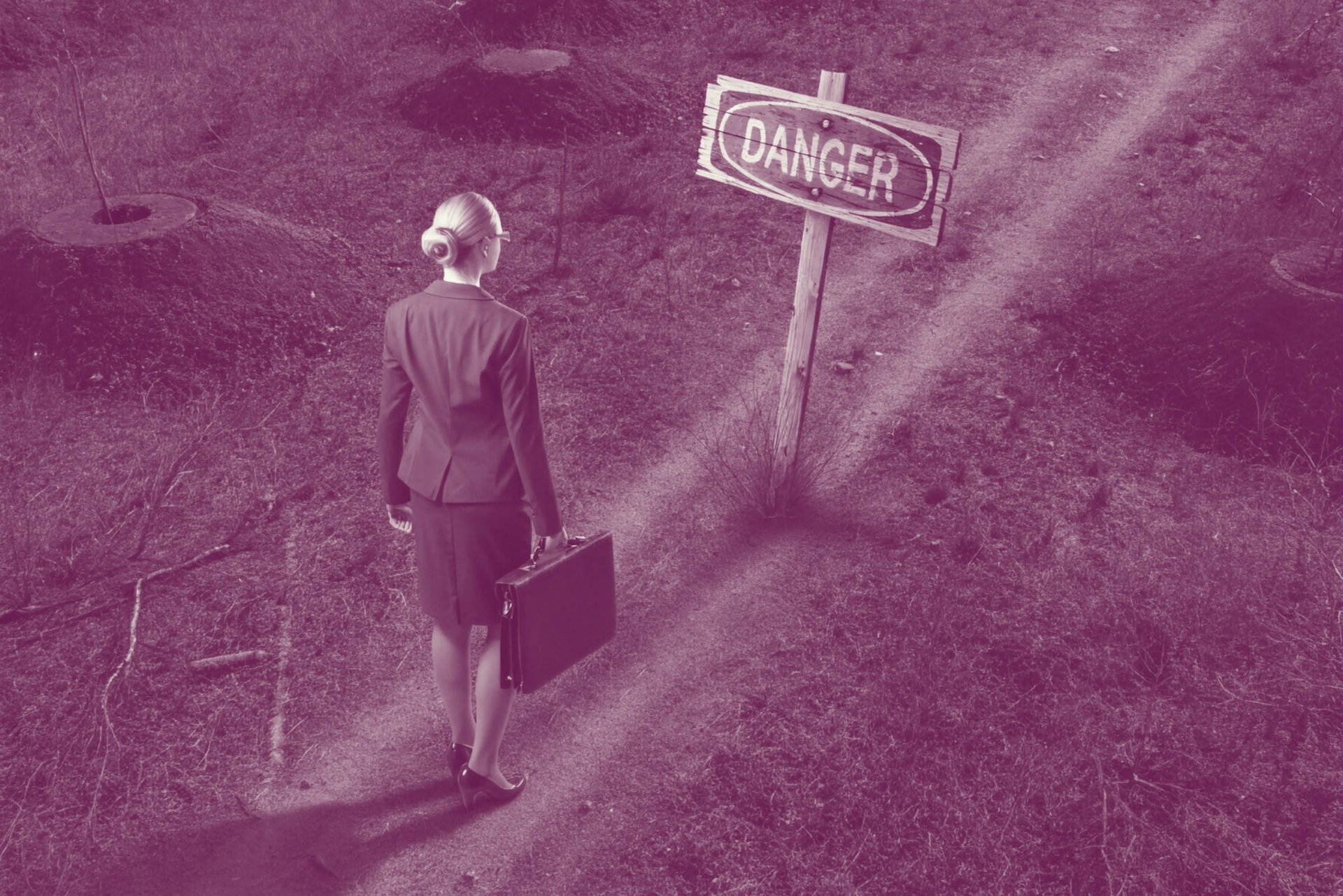 A businesswoman carrying a briefcase, entering a minefield.