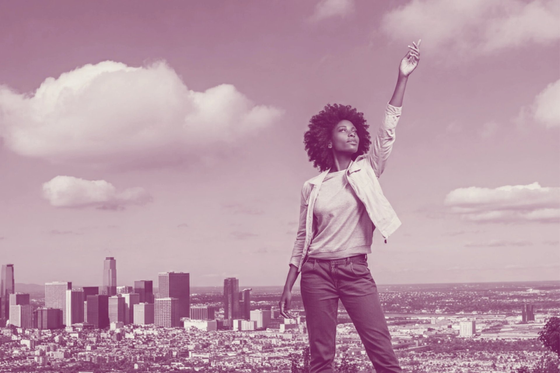 A black woman stands confidently, with a city skyline in the background.