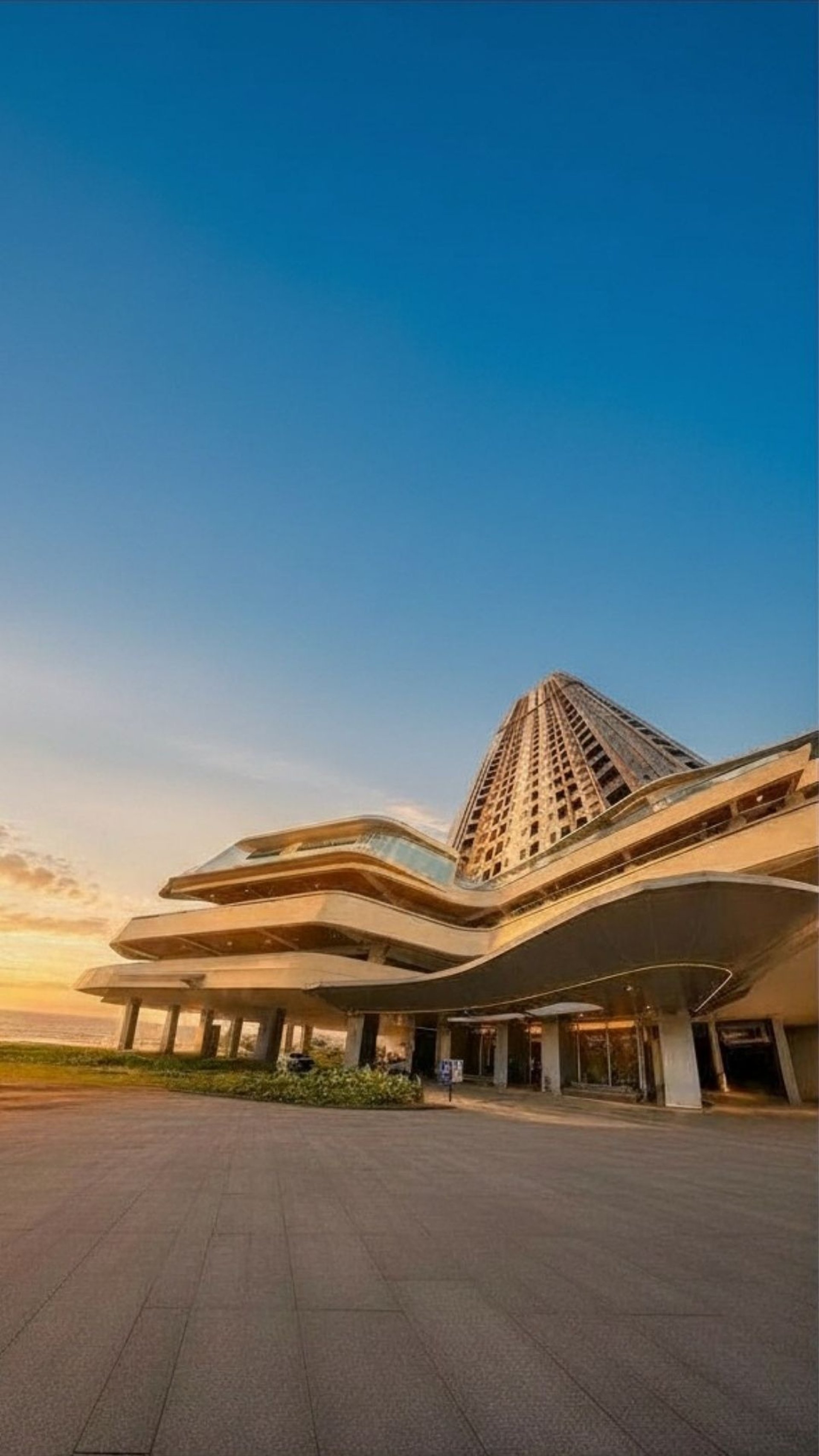 an abstract photo of a curved building with a blue sky in the background