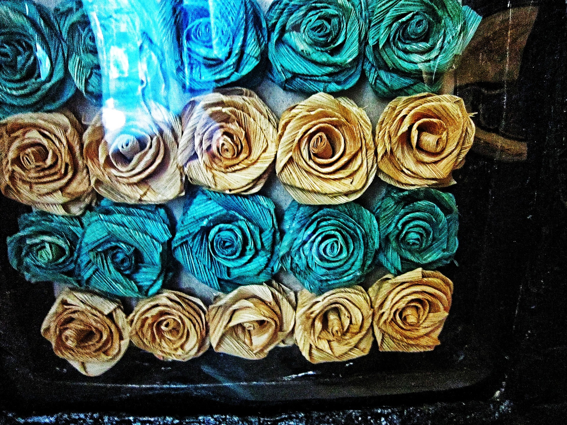 More loser of photograph of blue and white natural corn husk rose inside of frame 