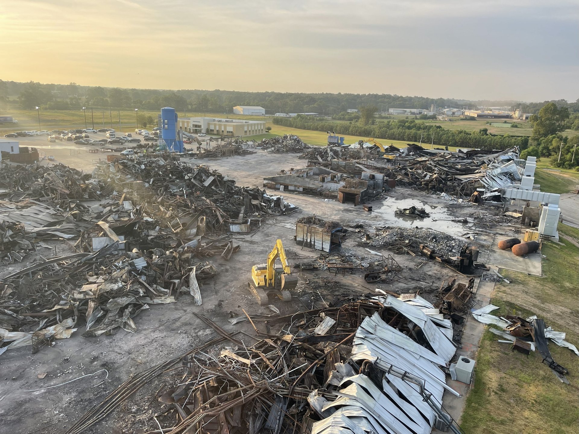 Large commercial demolition site with excavator separating materials