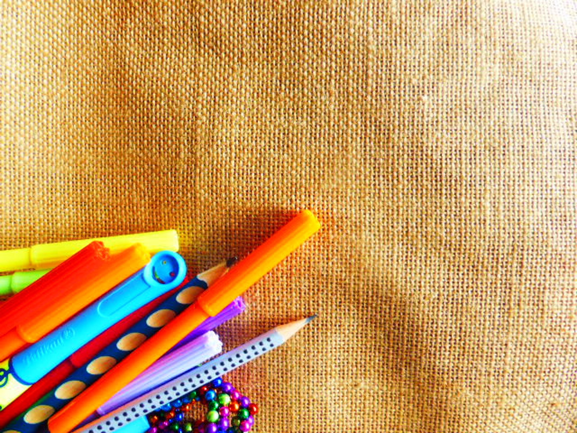 a cup filled with colored pencils on top of a wooden table