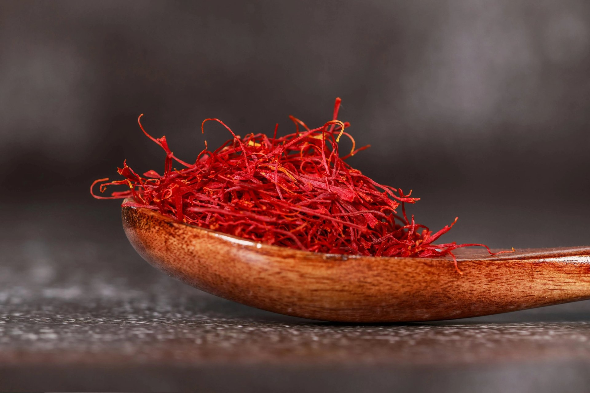 Uma colher de pau cheia de fios de açafrão vermelho pertencente à ME Saffron Company