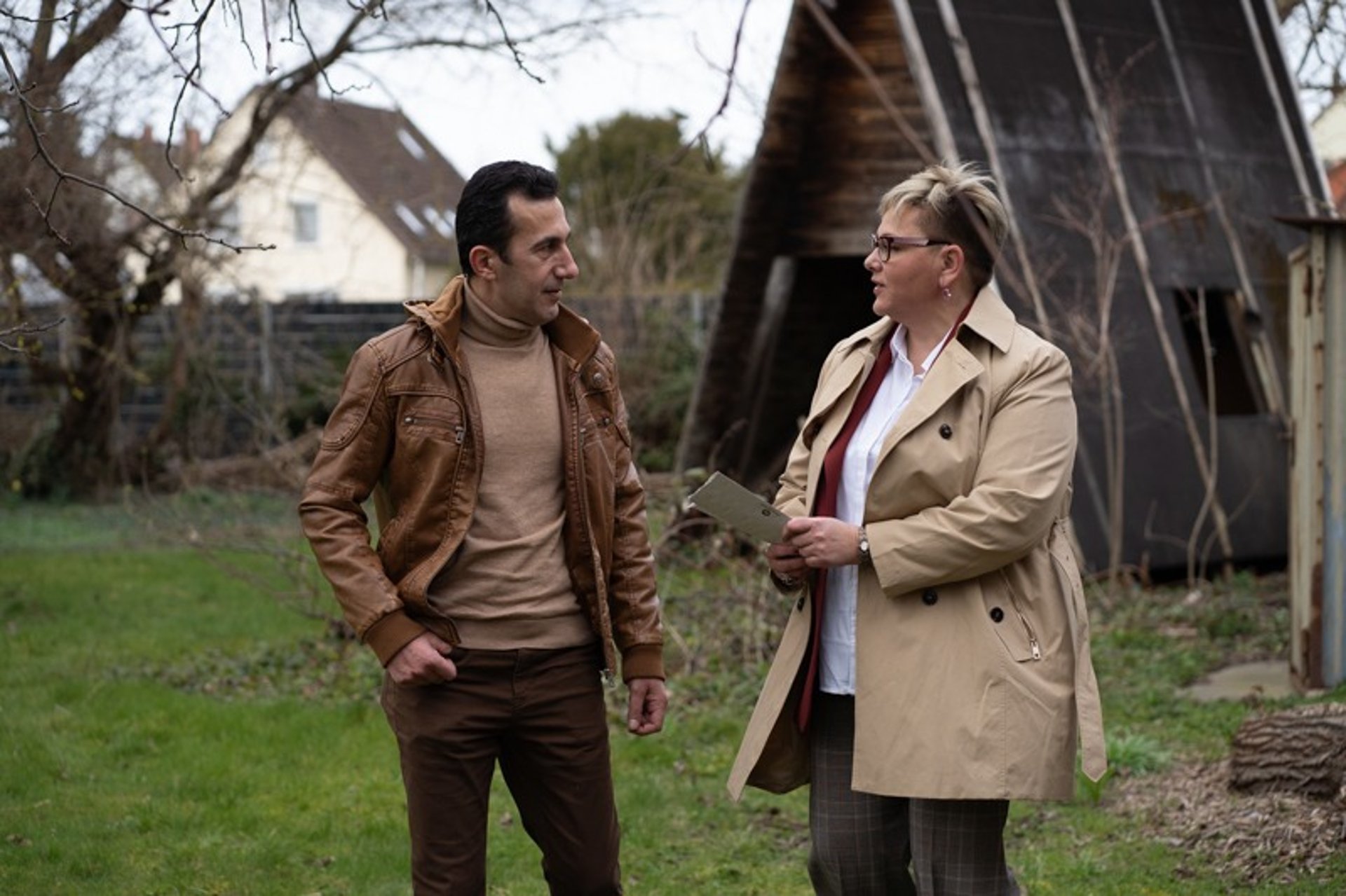 two women taking to each other while holding pens