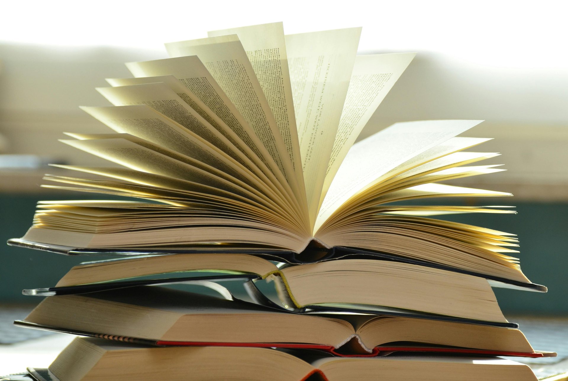 clear glass mug on three stacked books inside room