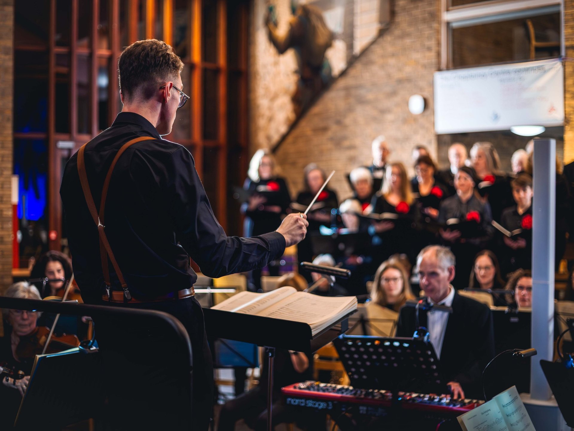 An over the shoulder photo of a maestro directing an orchestra