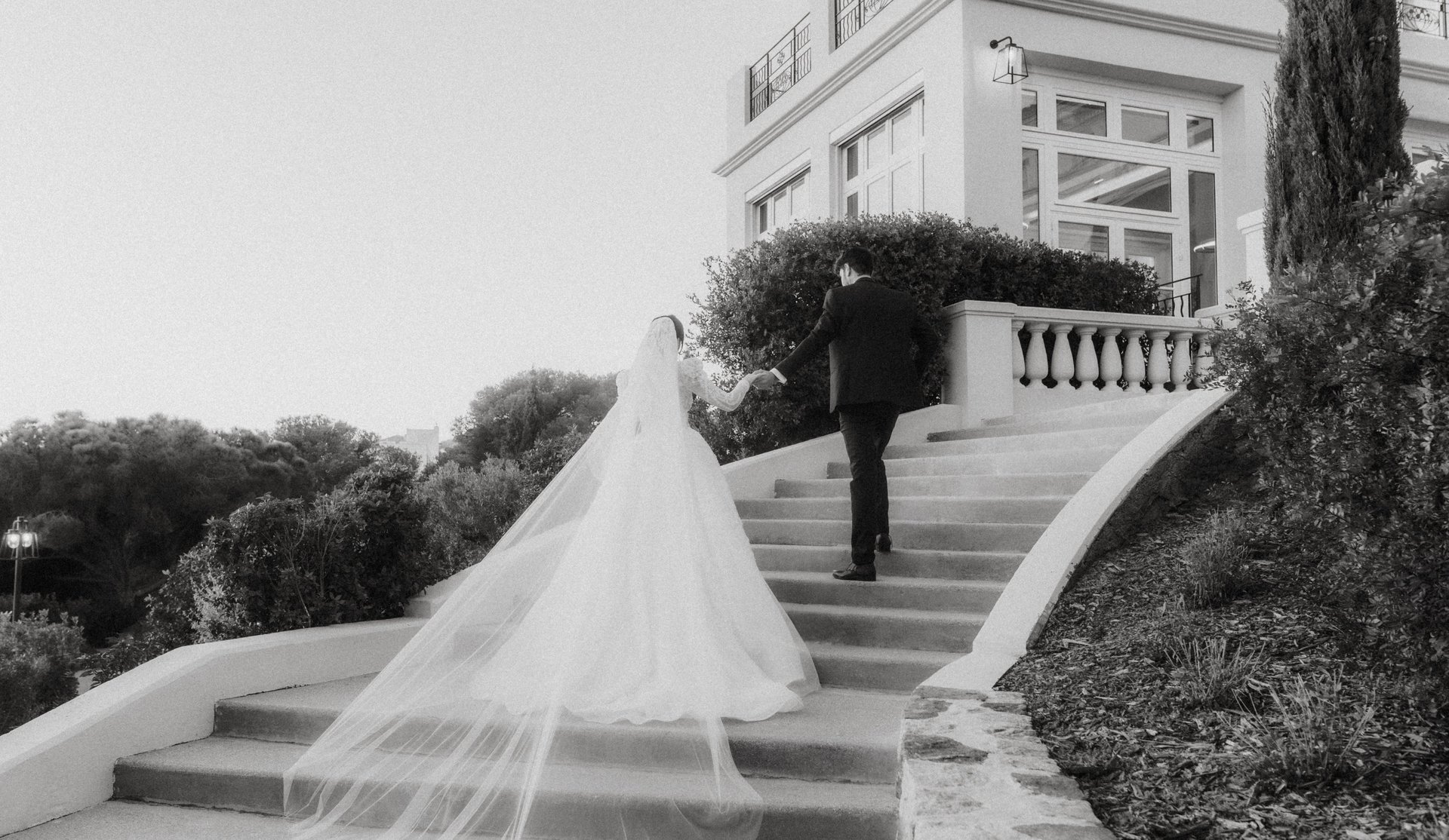 Bride and groom walking up the stairs of a luxury villa in the French Riviera at sunset
