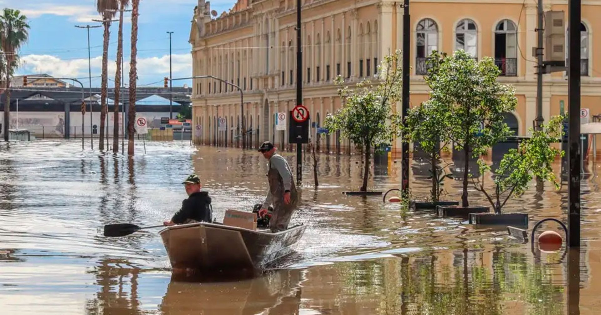 woman in blue t-shirt and white cap sitting on brown sand during daytime