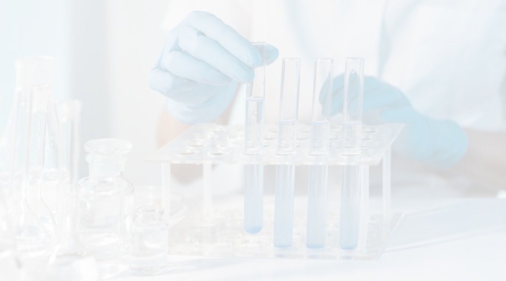 a gloved hand holding a test tube filled with liquid