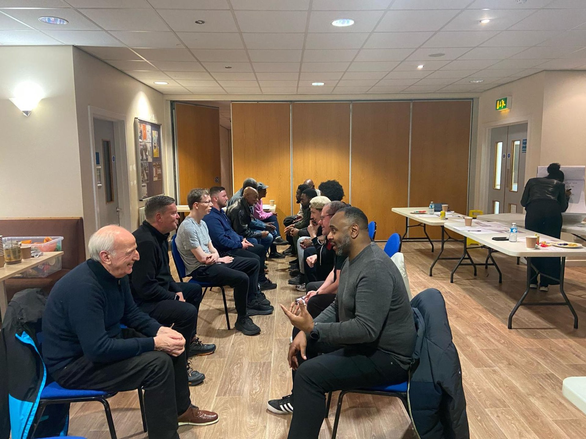 row of four men sitting on mountain trail