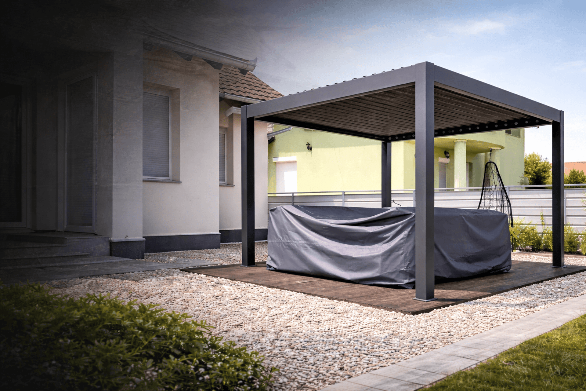 a covered patio with a couch and chairs