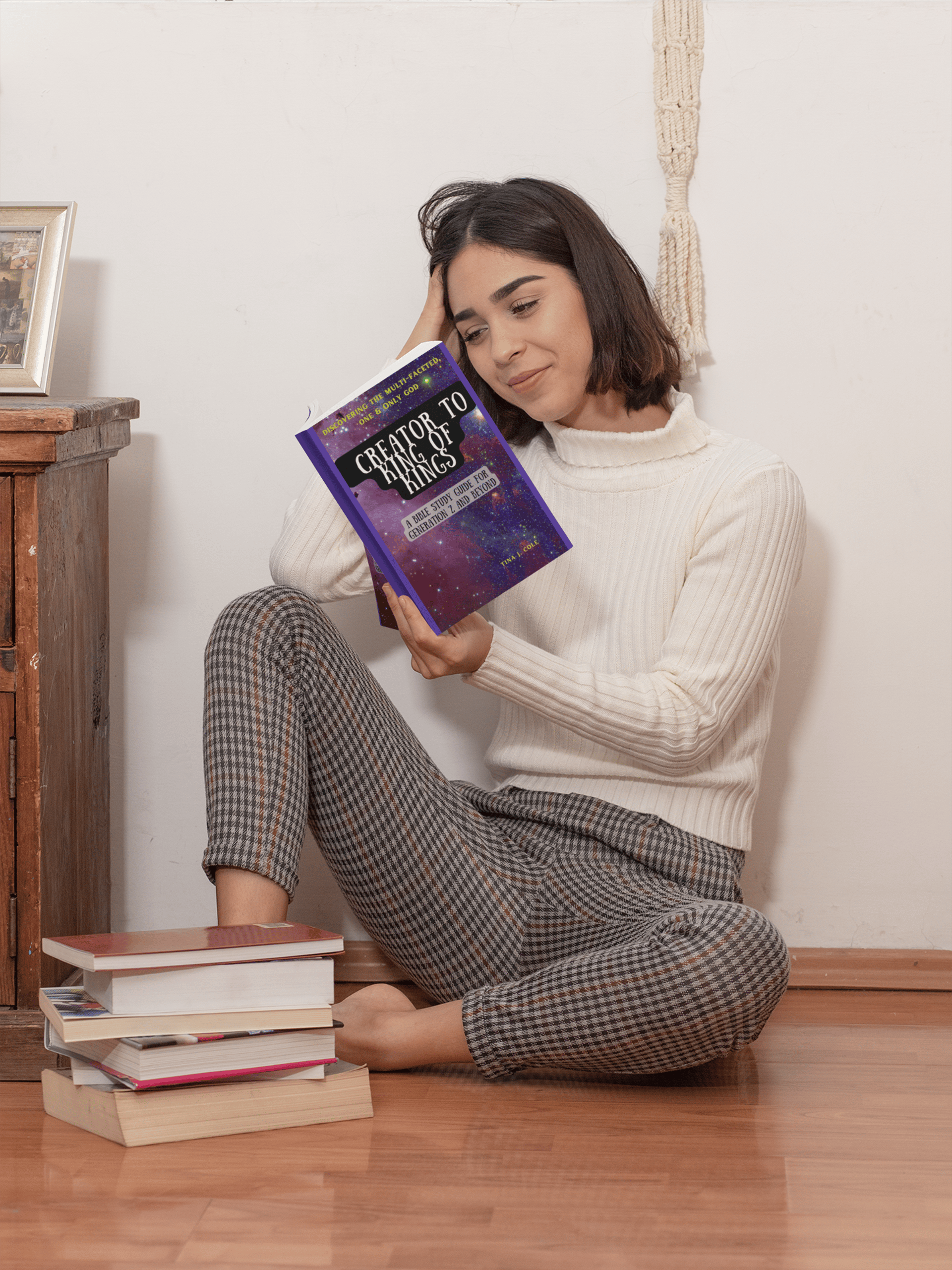 Girl sitting on floor reading Creator To King of Kings bible study 
