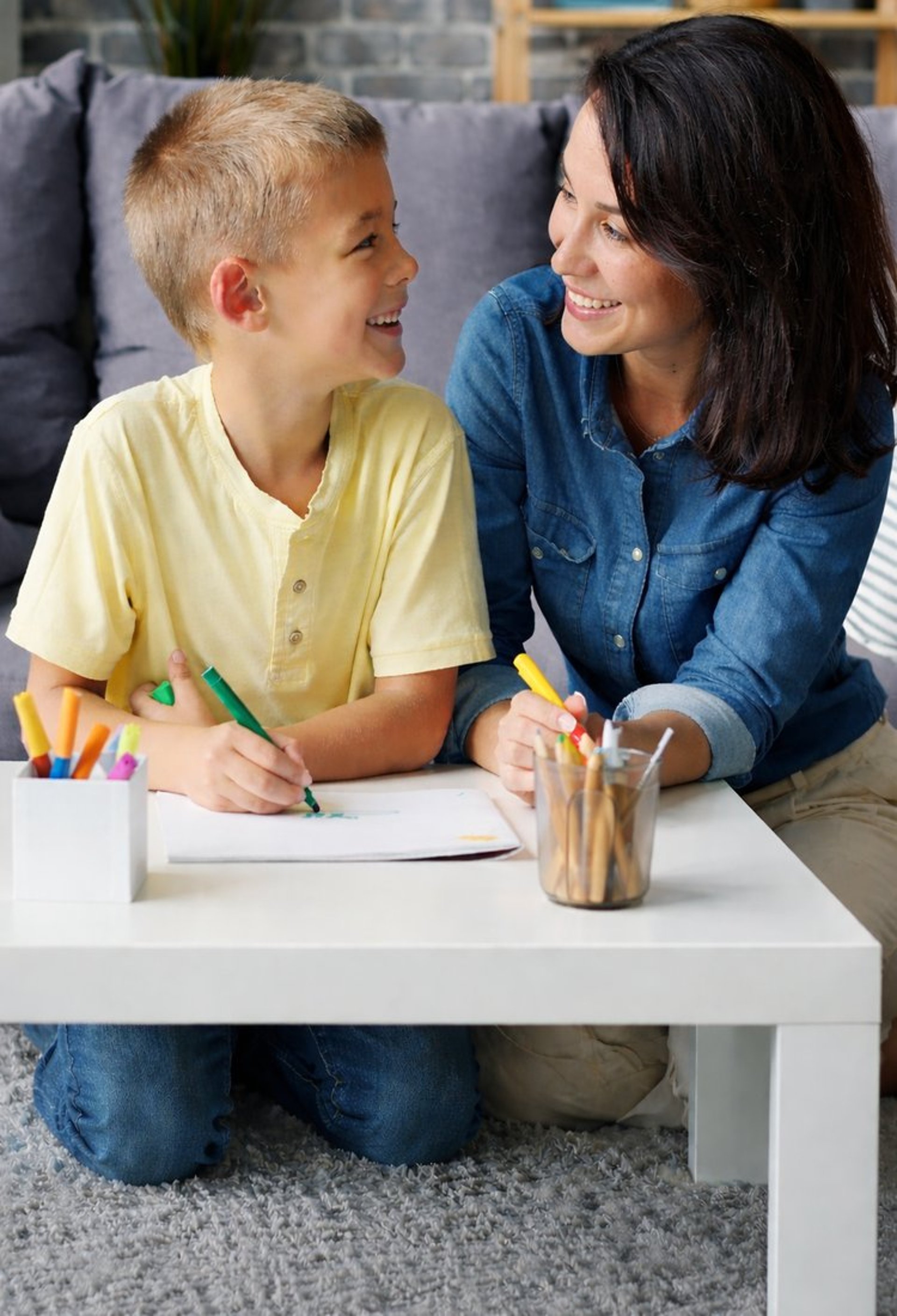 Mother and son drawing at a table together.