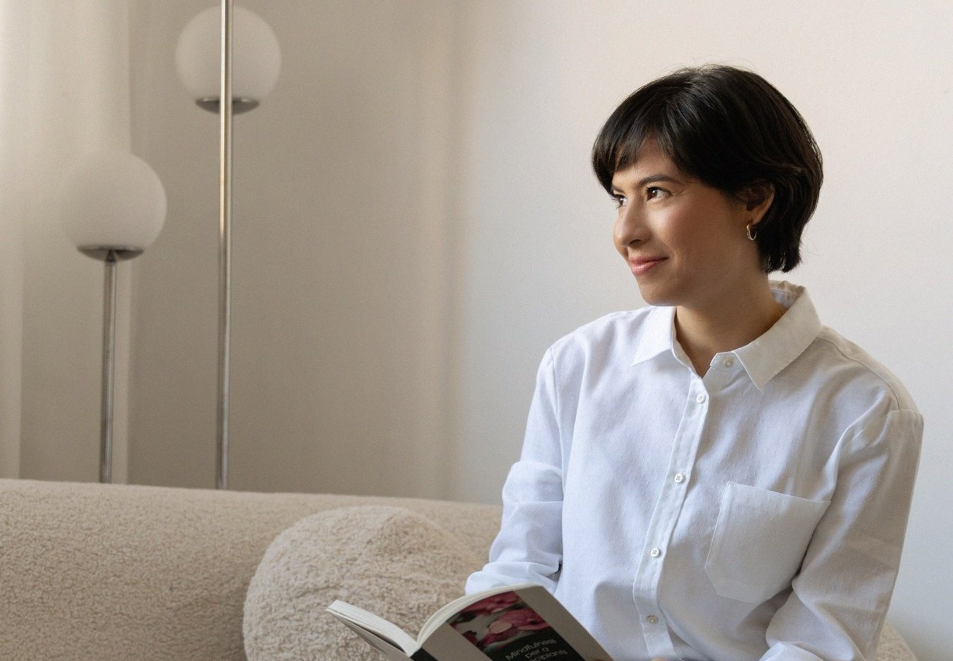 person holding white ceramic mug with brown and white beans