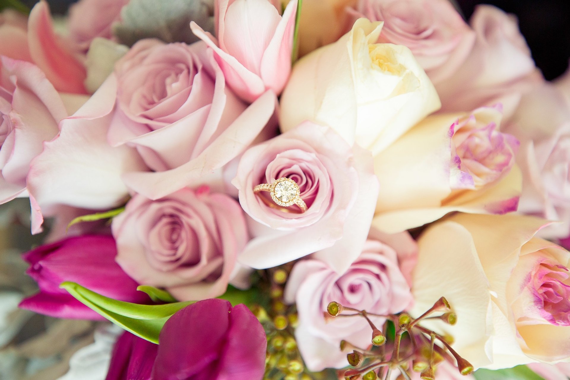 woman standing beside wall holding flowers