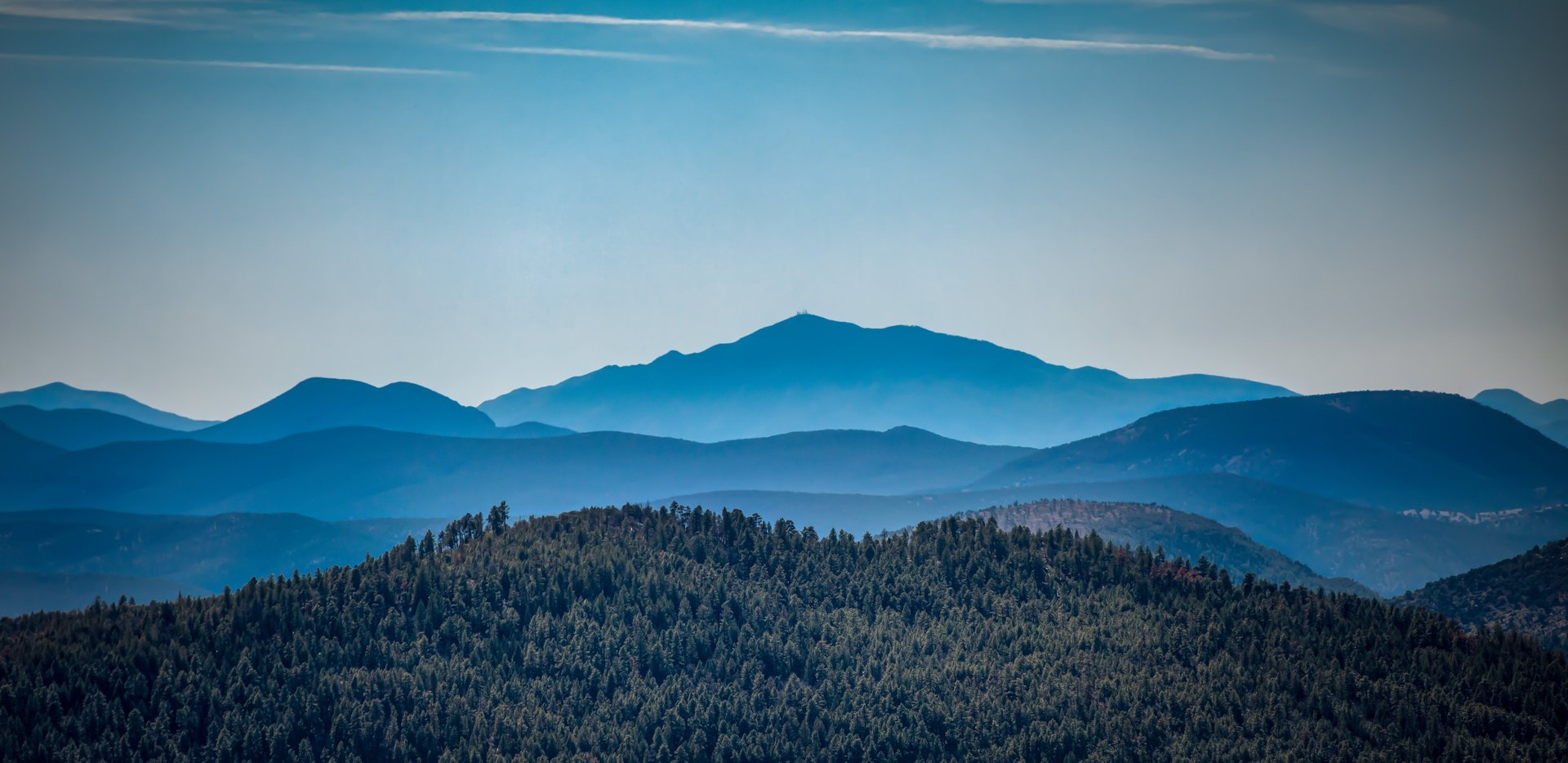 an abstract photo of a curved building with a blue sky in the background