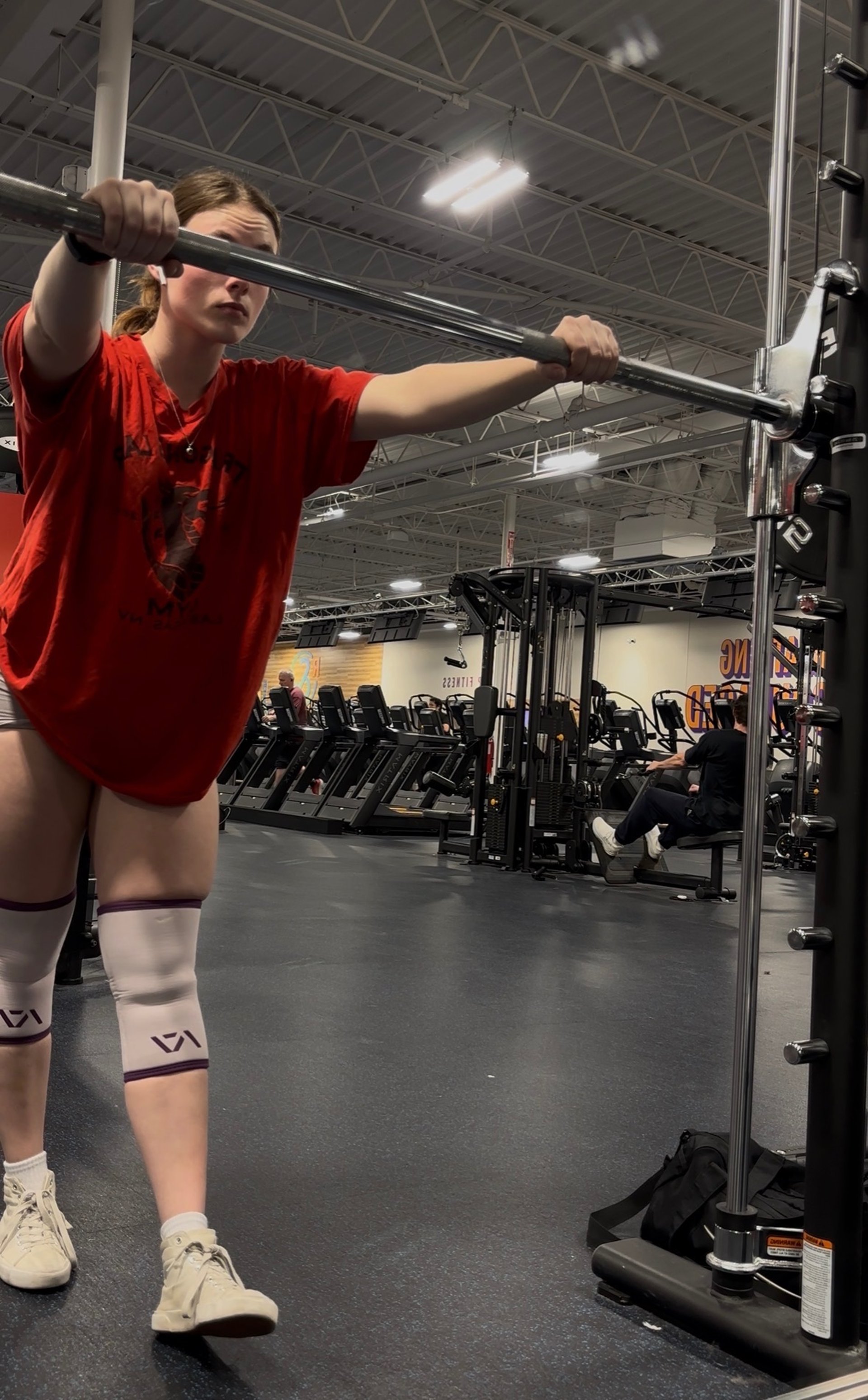 a gym with a row of exercise equipment