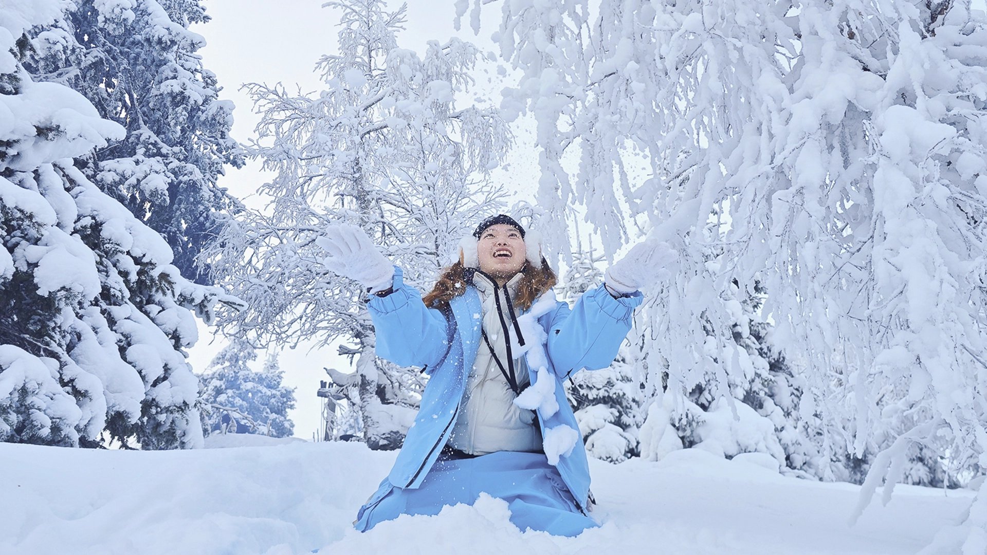 Guest playing in deep Arctic powder snow among snow-covered trees in Riisitunturi National Park, Finnish Lapland.