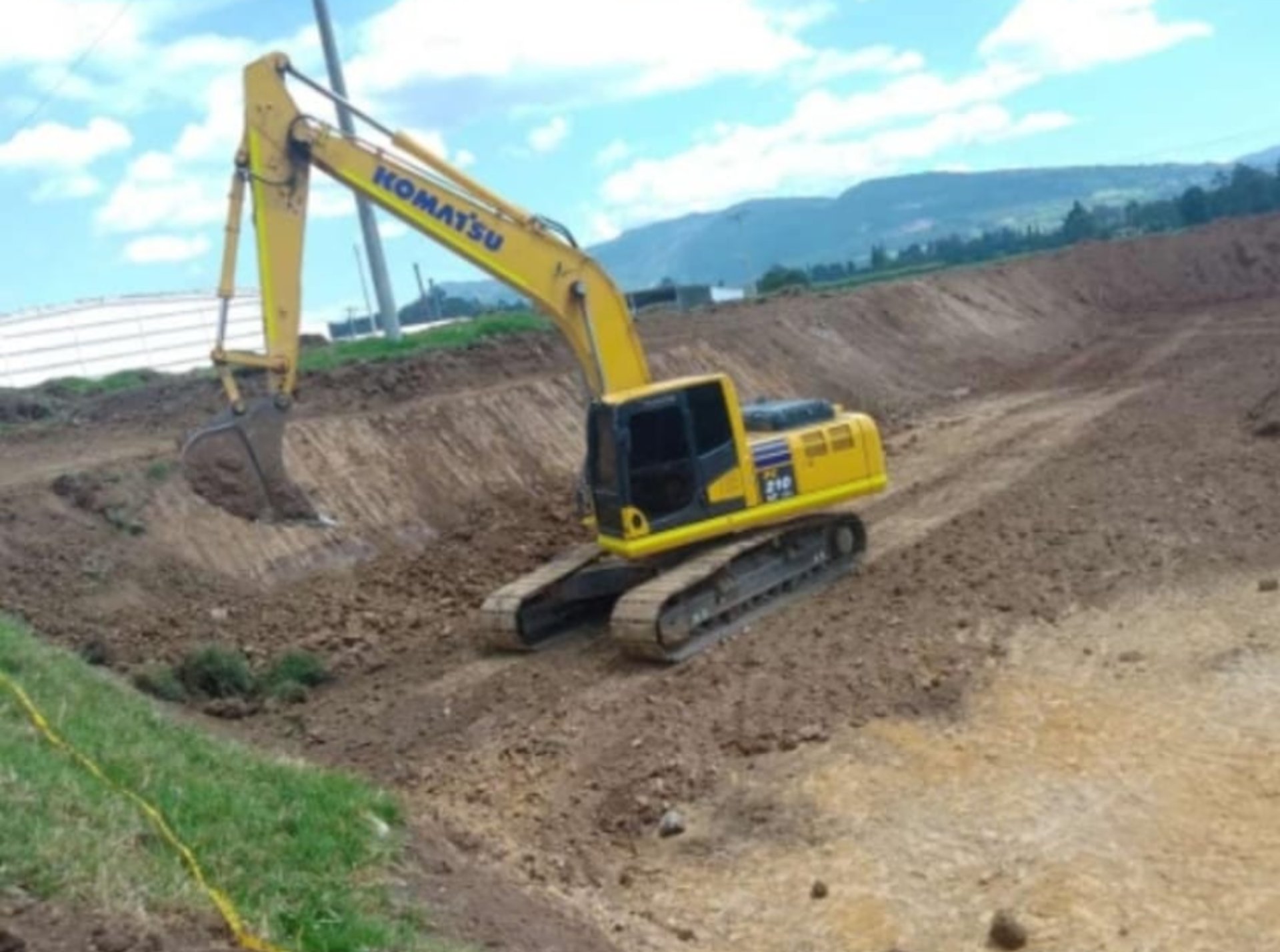A large yellow excavator sitting on top of a pile of dirt