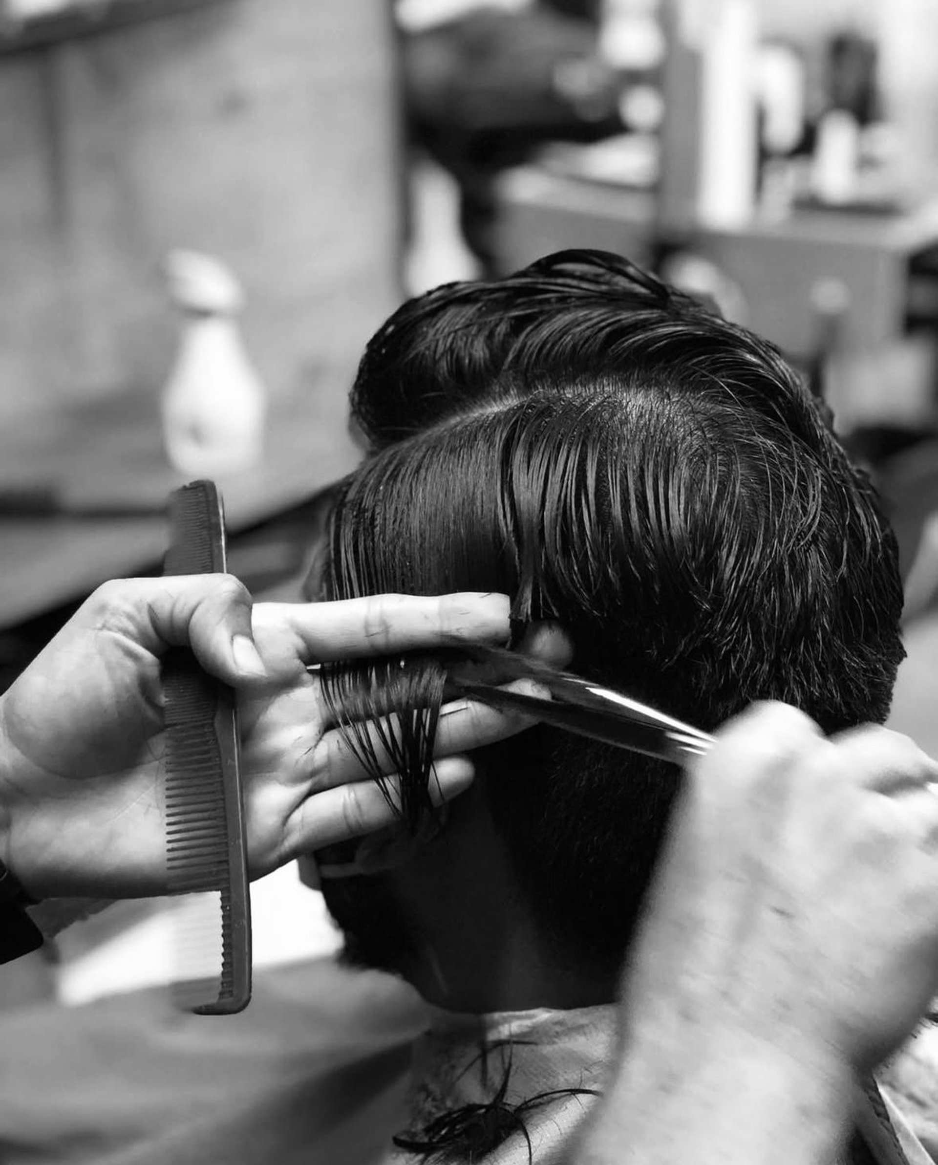 grayscale photo of man shaving his beard