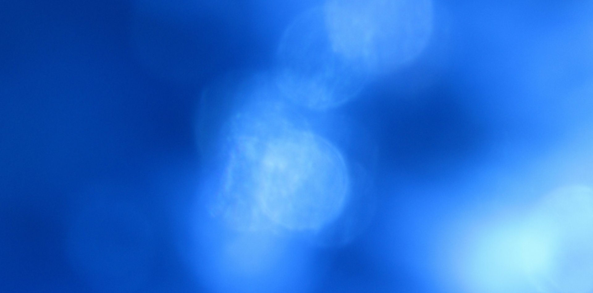 an abstract photo of a curved building with a blue sky in the background