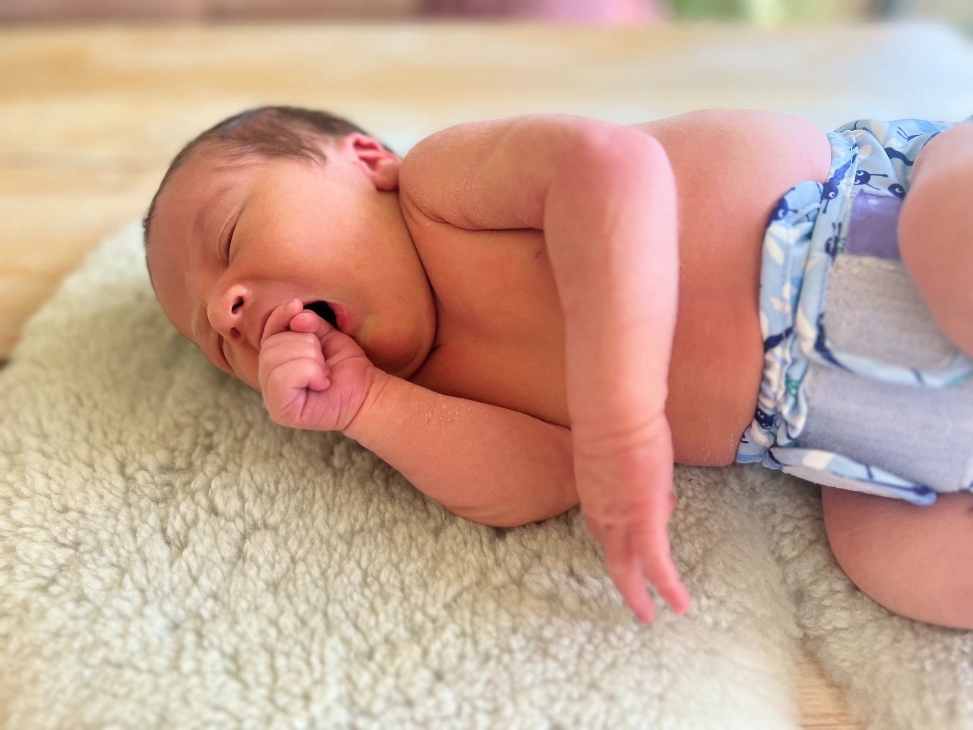 Newborn baby held gently in caring hands