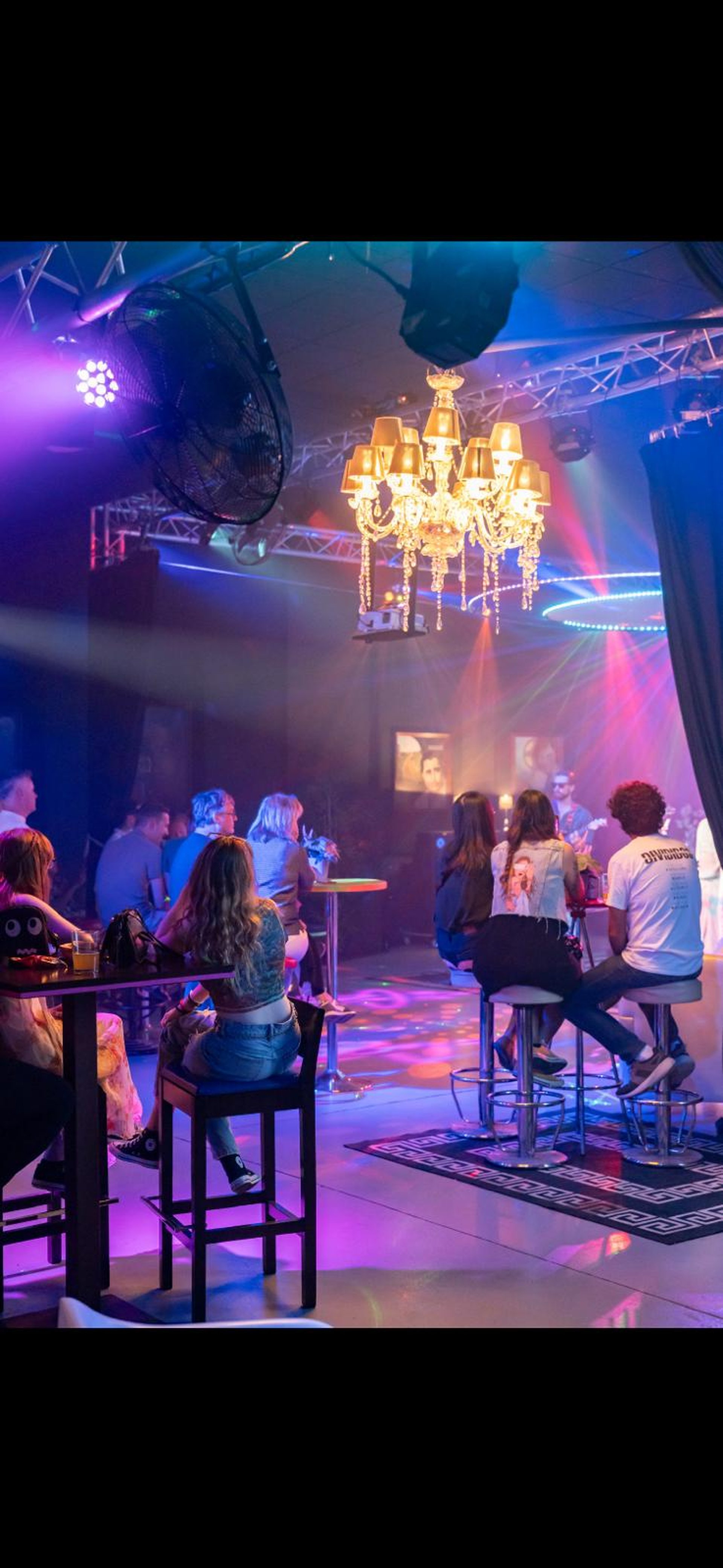 a stage with a laptop and microphone in front of a crowd