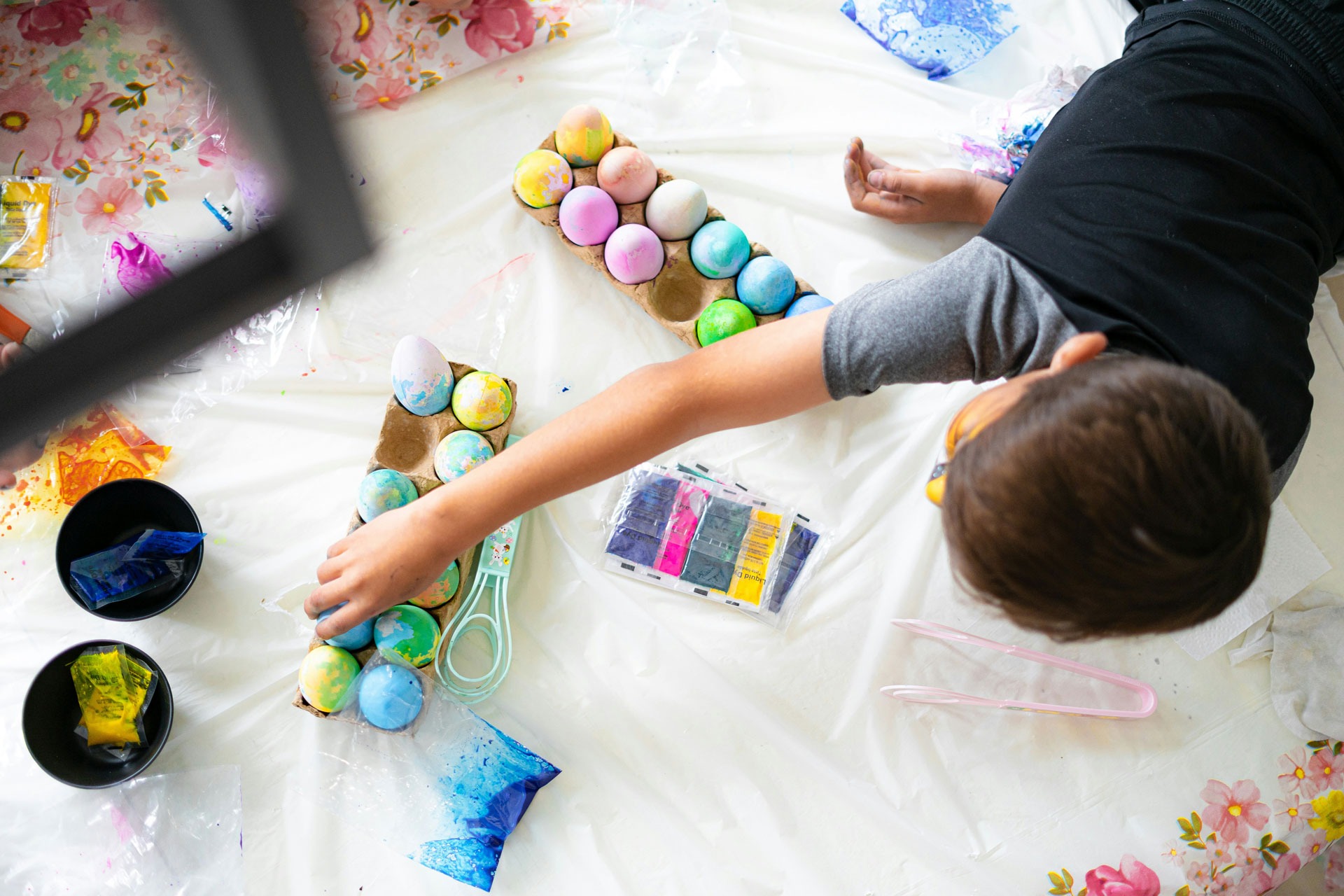 A young girl painting on a canvas at a table.