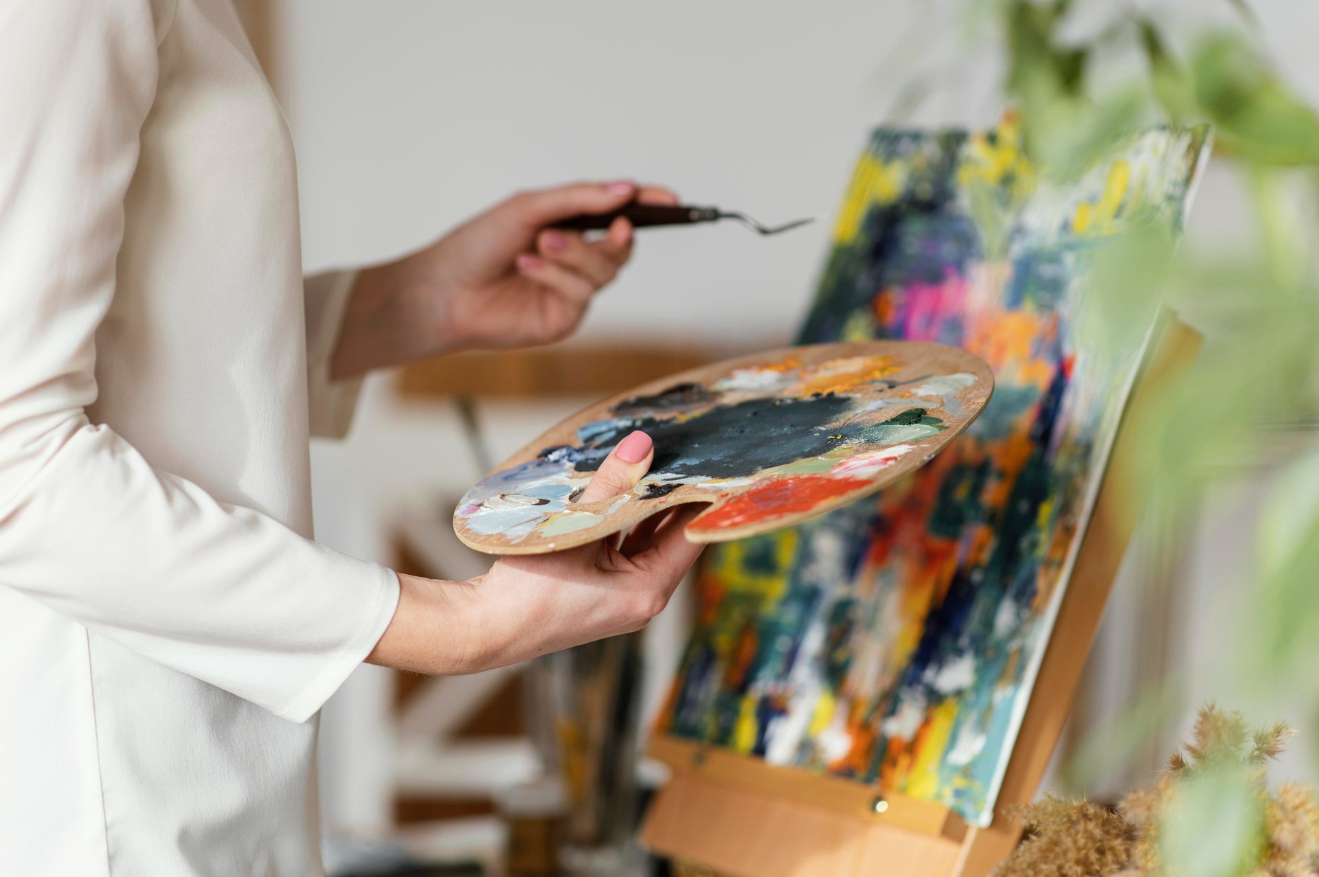 A young girl painting on a canvas at a table.