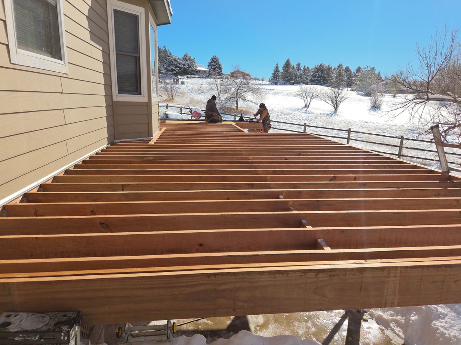 Wide view of a deck joist layout and framing progression for a multi-level deck build.