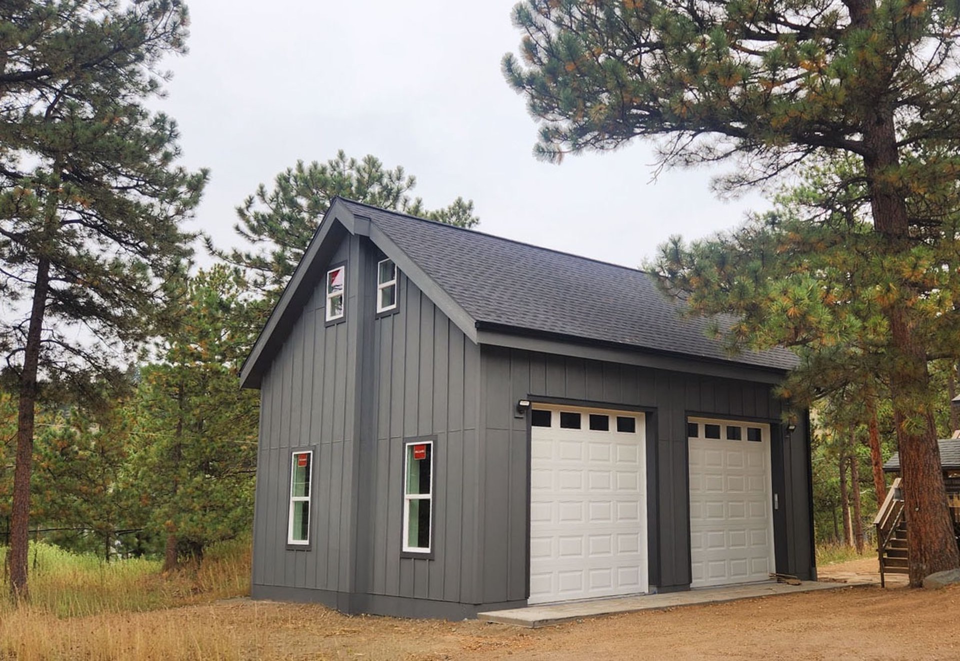Side profile of a custom mountain garage with dark vertical siding.