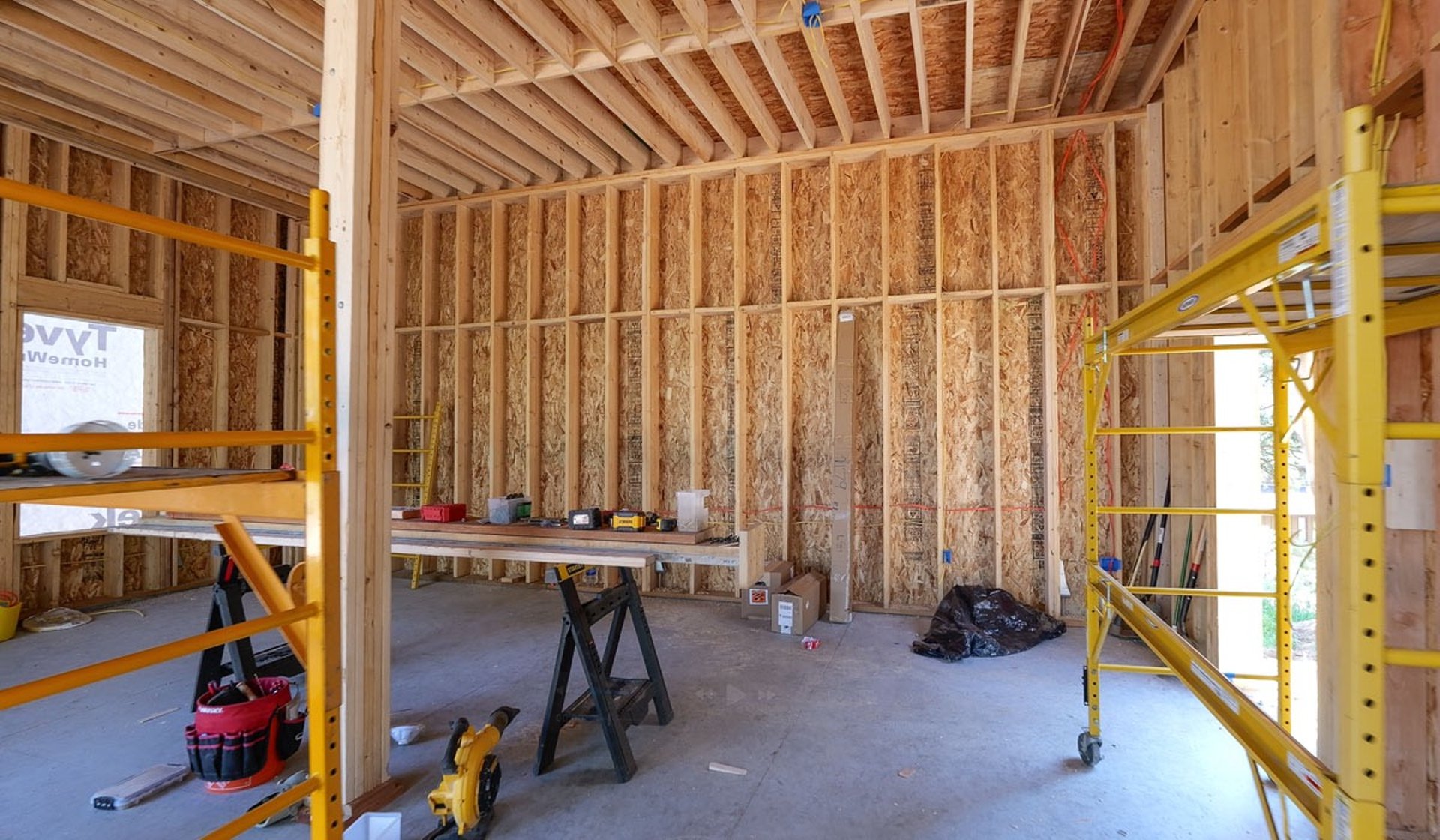 Interior garage framing with yellow scaffolding on-site.