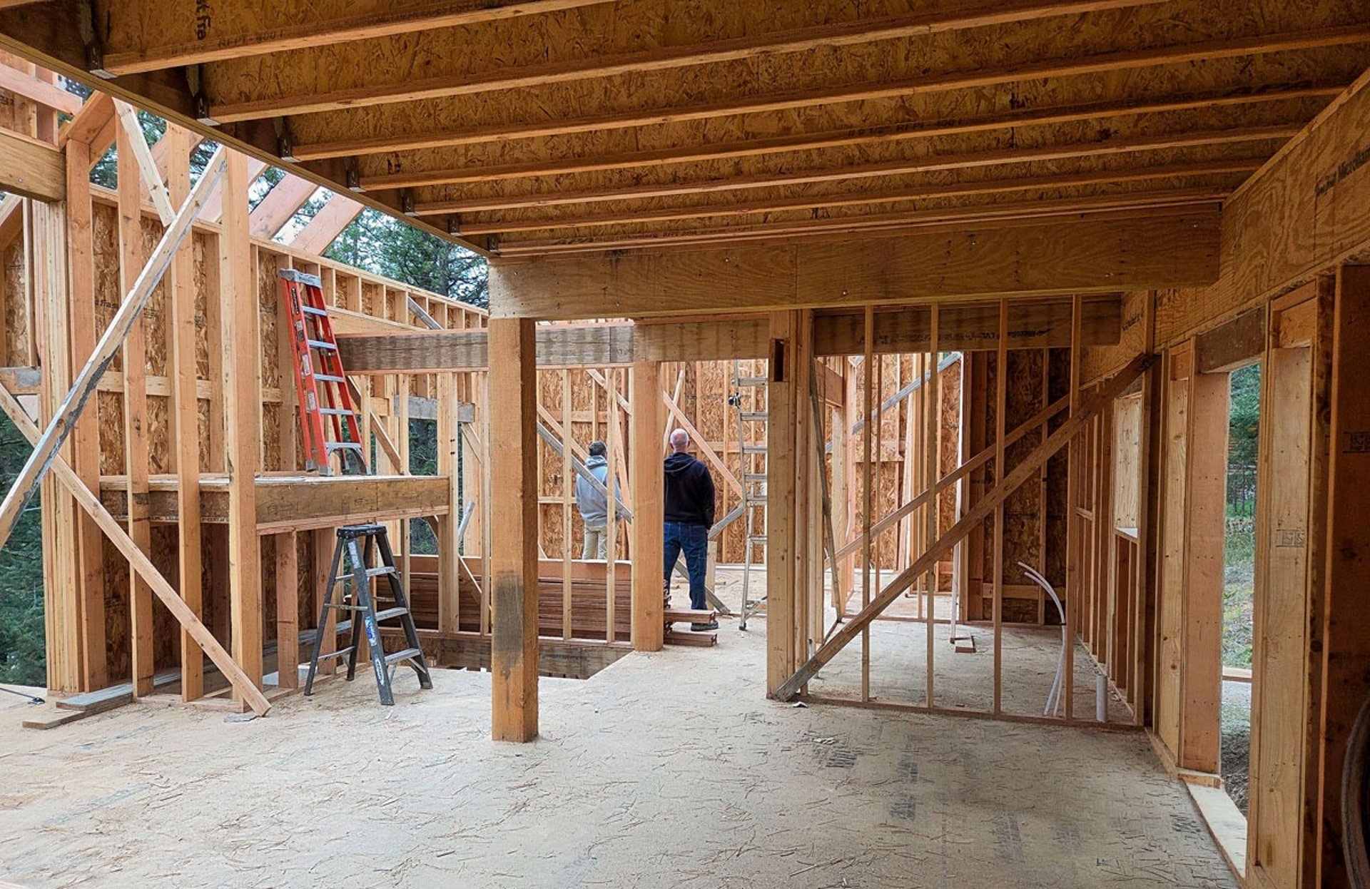 Interior structural wood framing showing open floor plan and support columns for a custom build.
