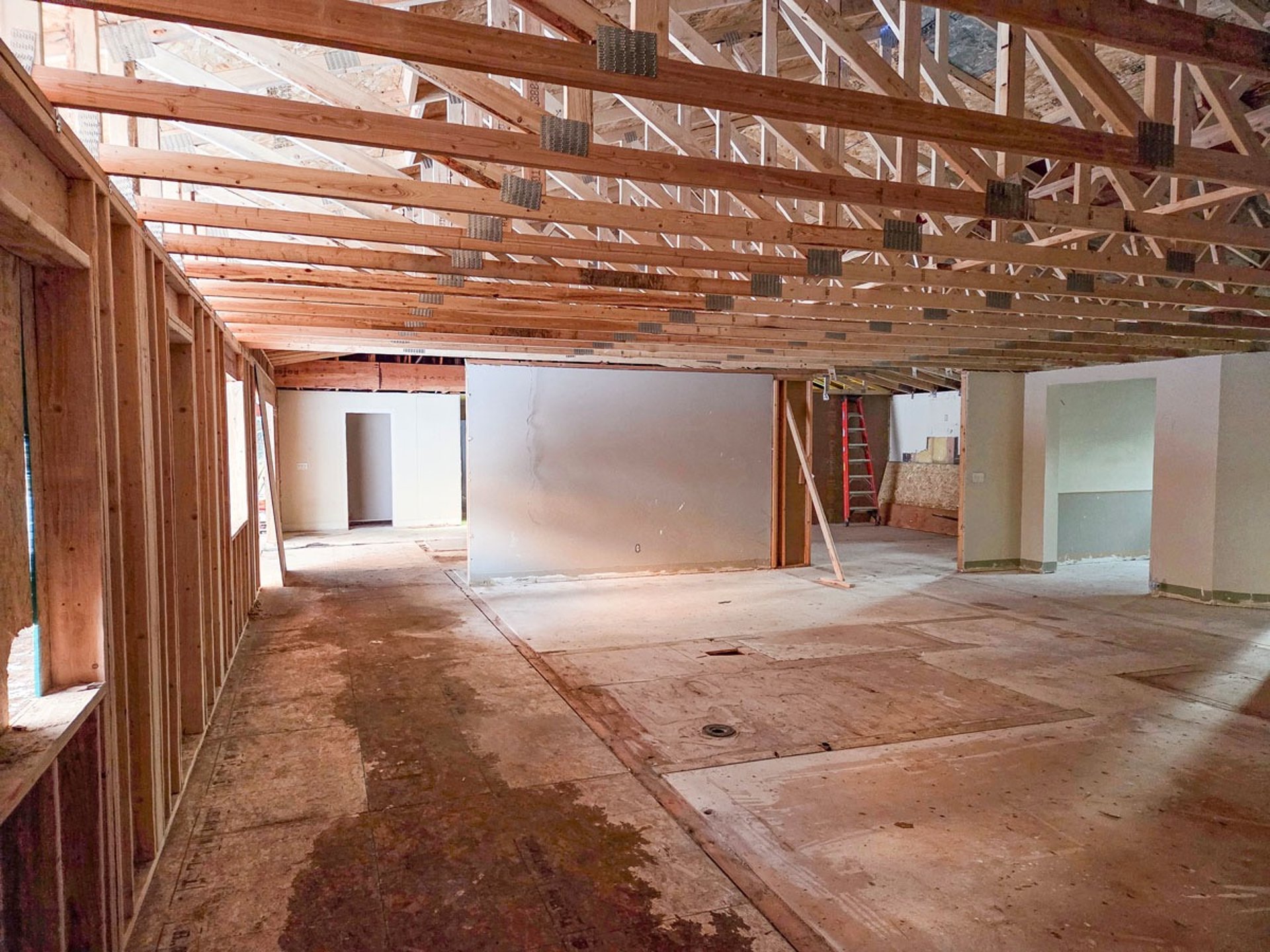 Interior perspective of open-web floor trusses and structural ceiling framing installation.