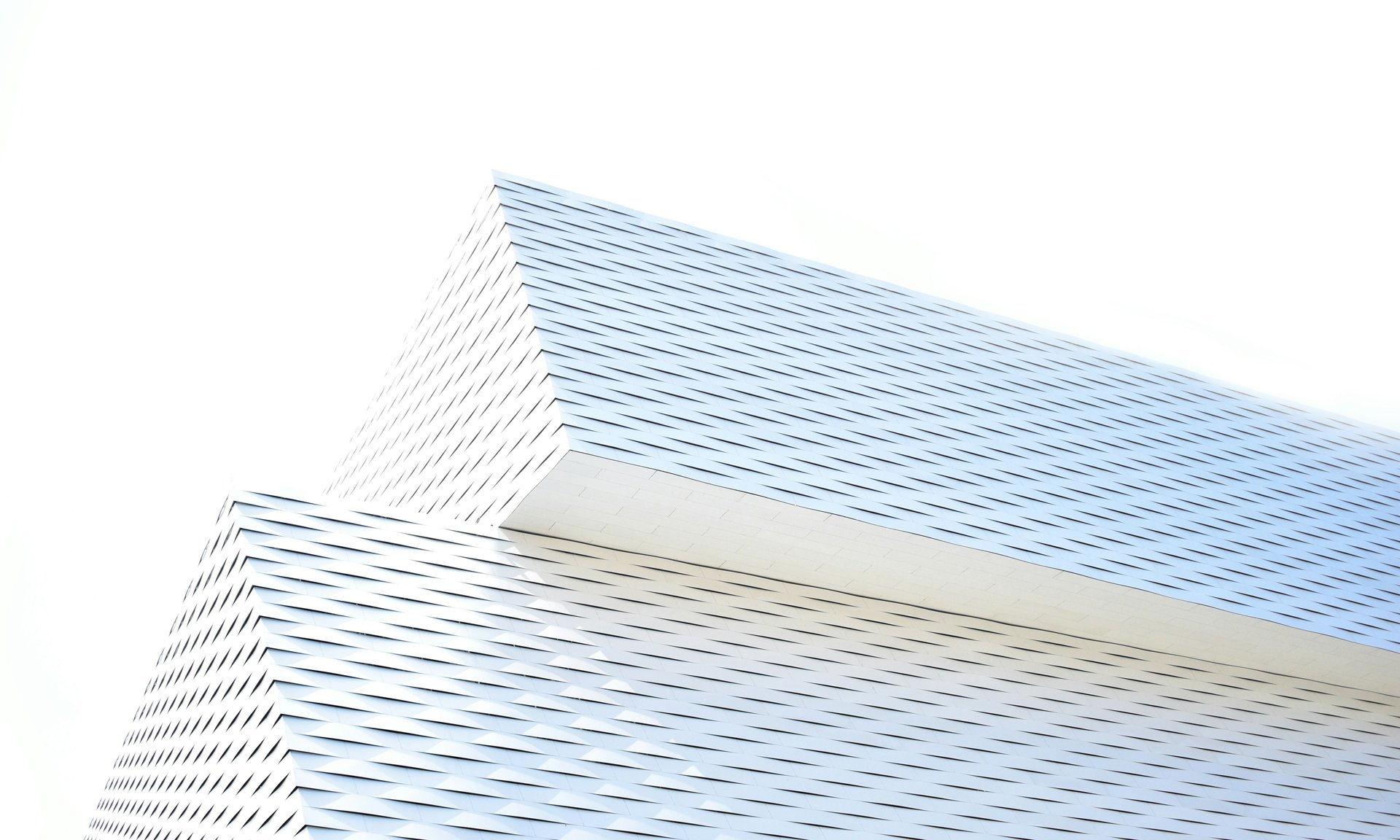 an abstract photo of a curved building with a blue sky in the background