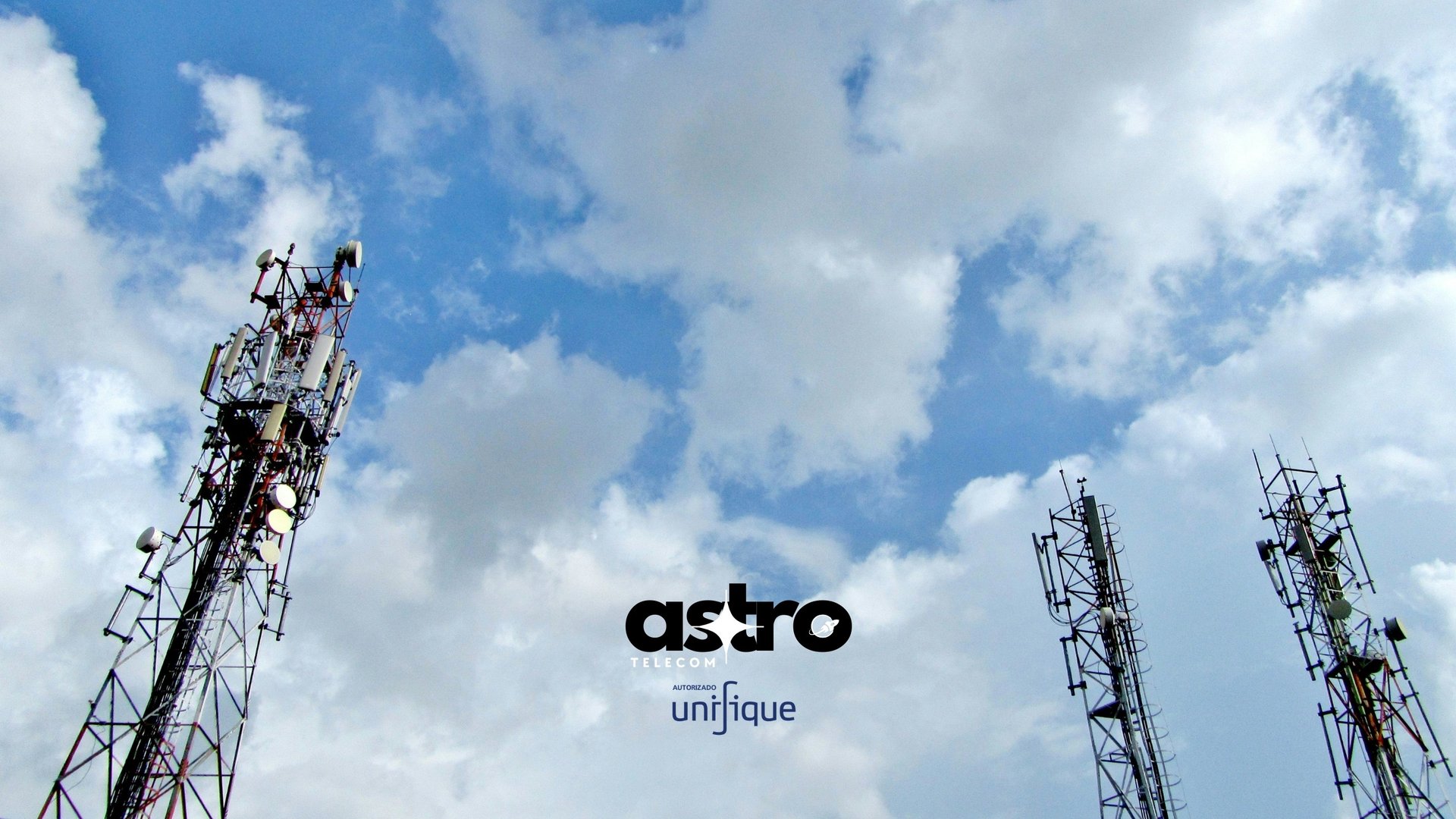 a group of cell towers sitting under a cloudy blue sky