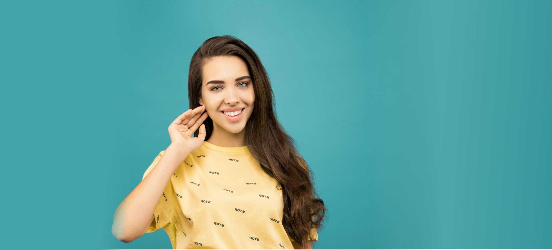 Mujer con sonrisa bonita con playera amarilla y fondo azul turquesa