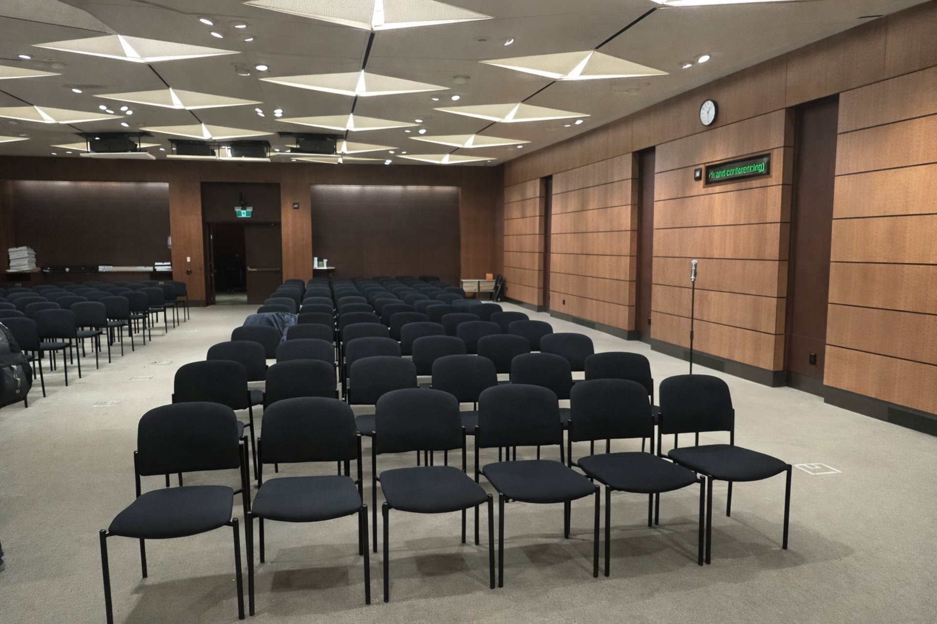 conference room with rows of chairs wood panel walls and microphone stand