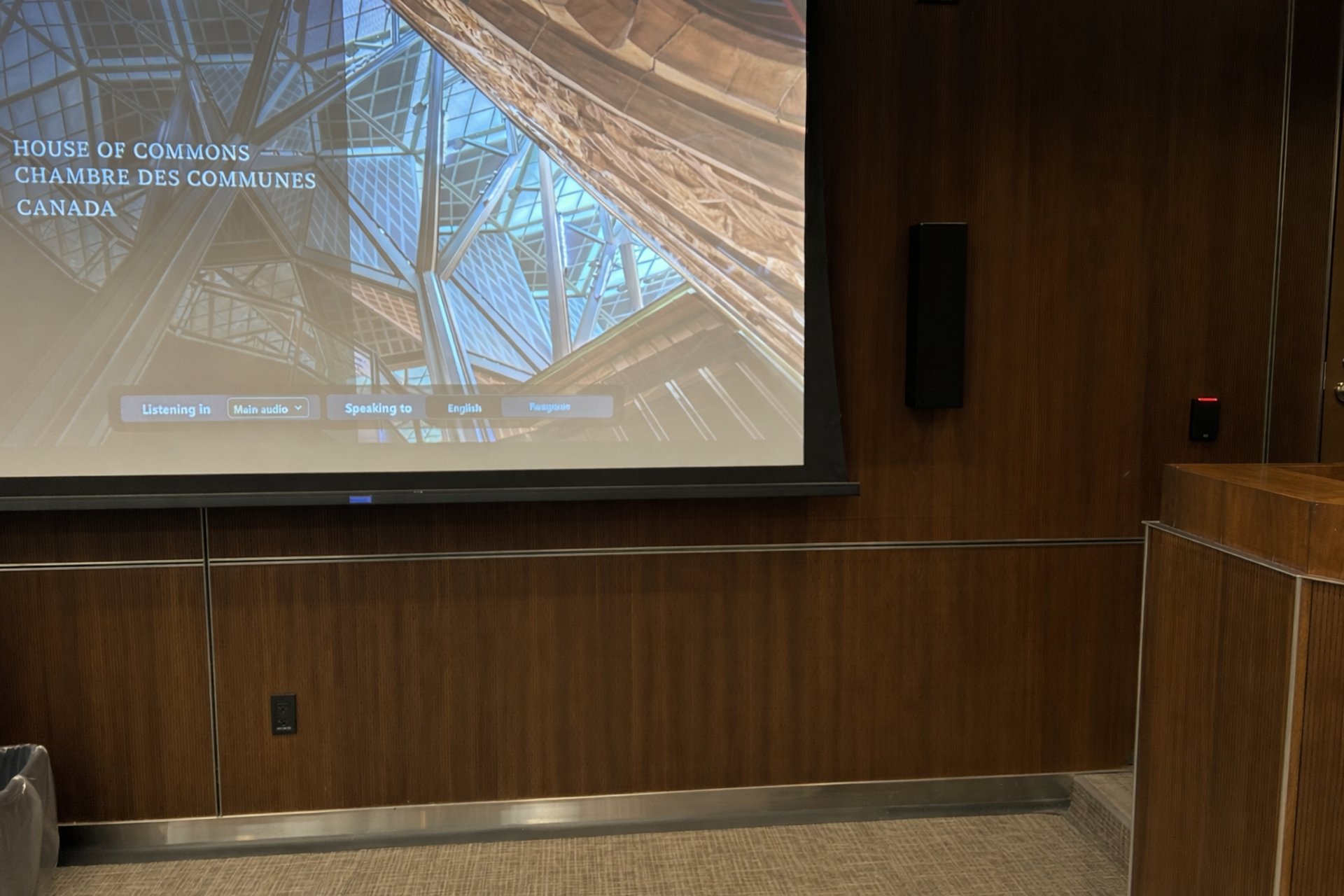 House of Commons conference room with large presentation screen and wall-mounted card reader access control.