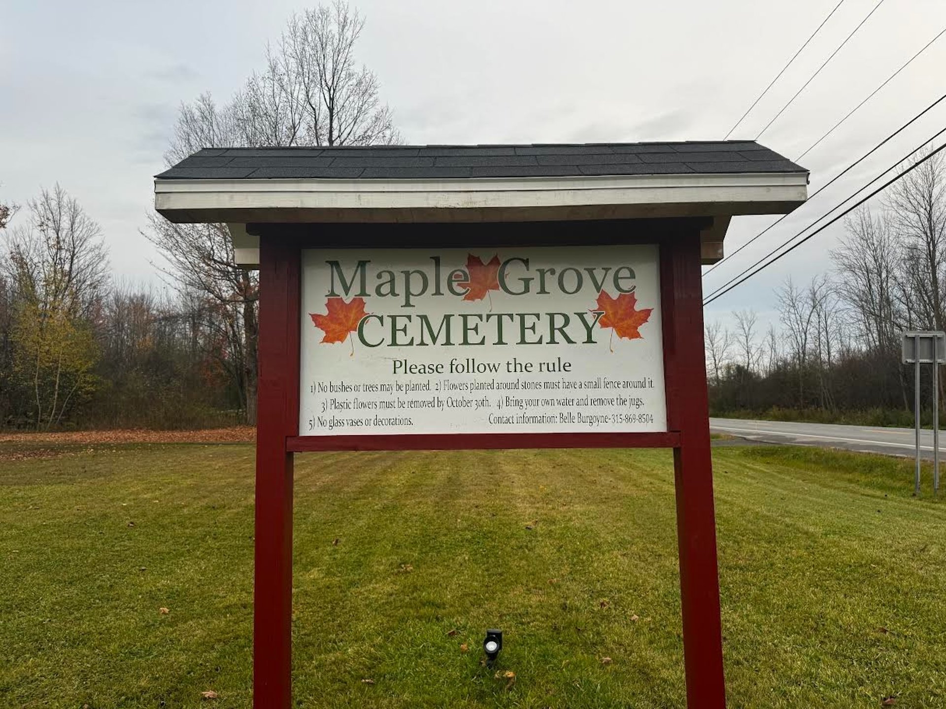 gray concrete cross on green grass field during daytime