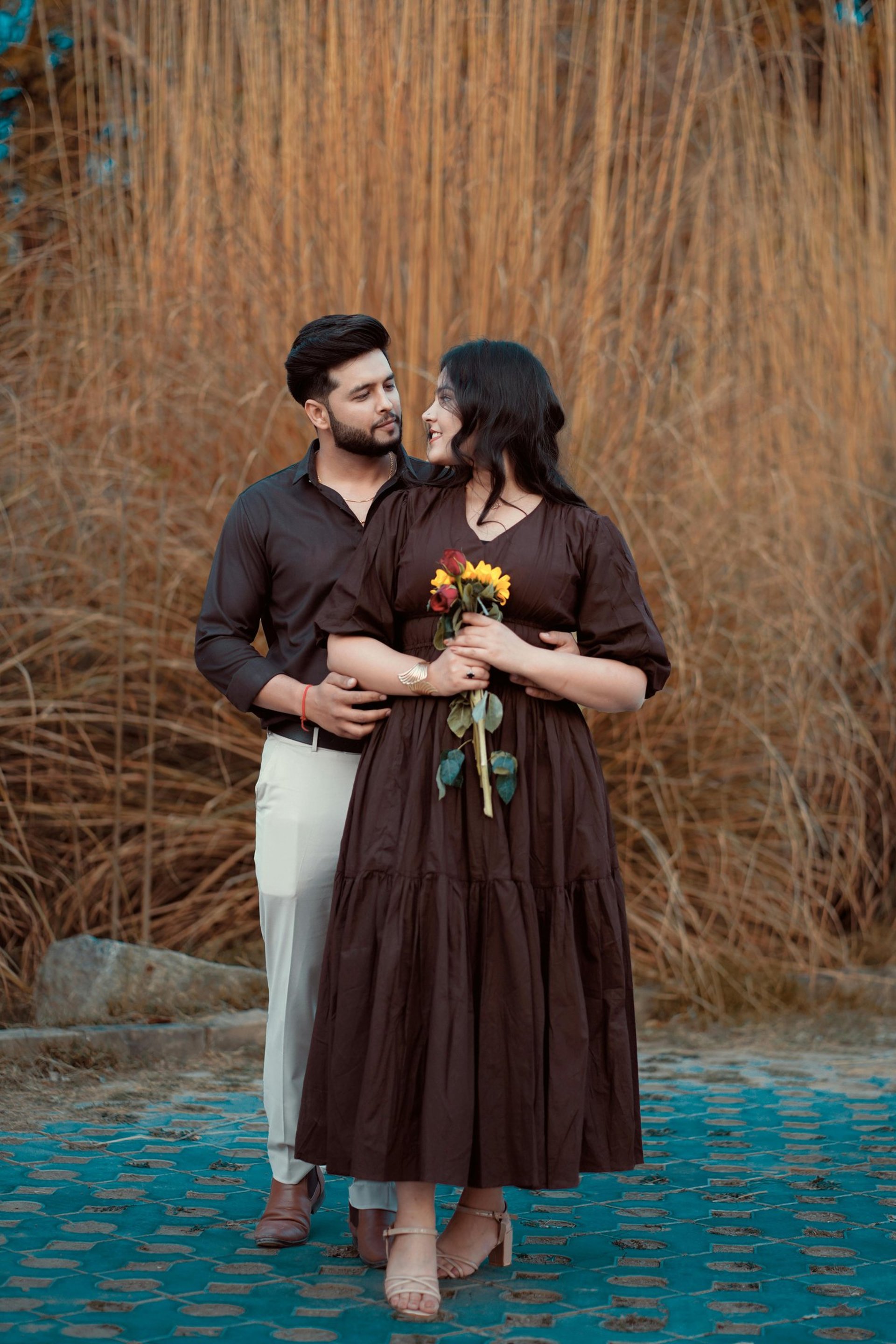 man kissing on woman forehead standing near tree during daytime