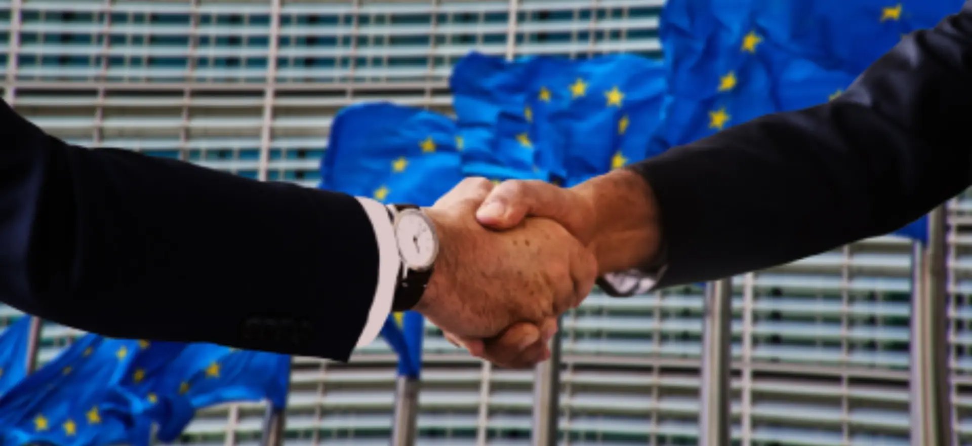 Business handshake with European Union flag in background representing EU partnership